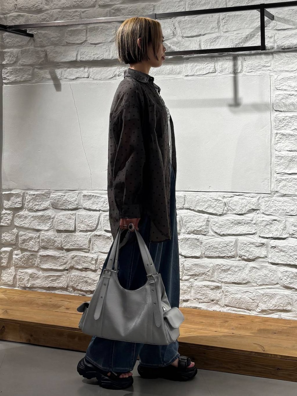 ブラック系のキャミソール、ブルー系のデニムパンツ、ブラック系のサンダルを着用したレディースの春コーディネートの4枚目の写真