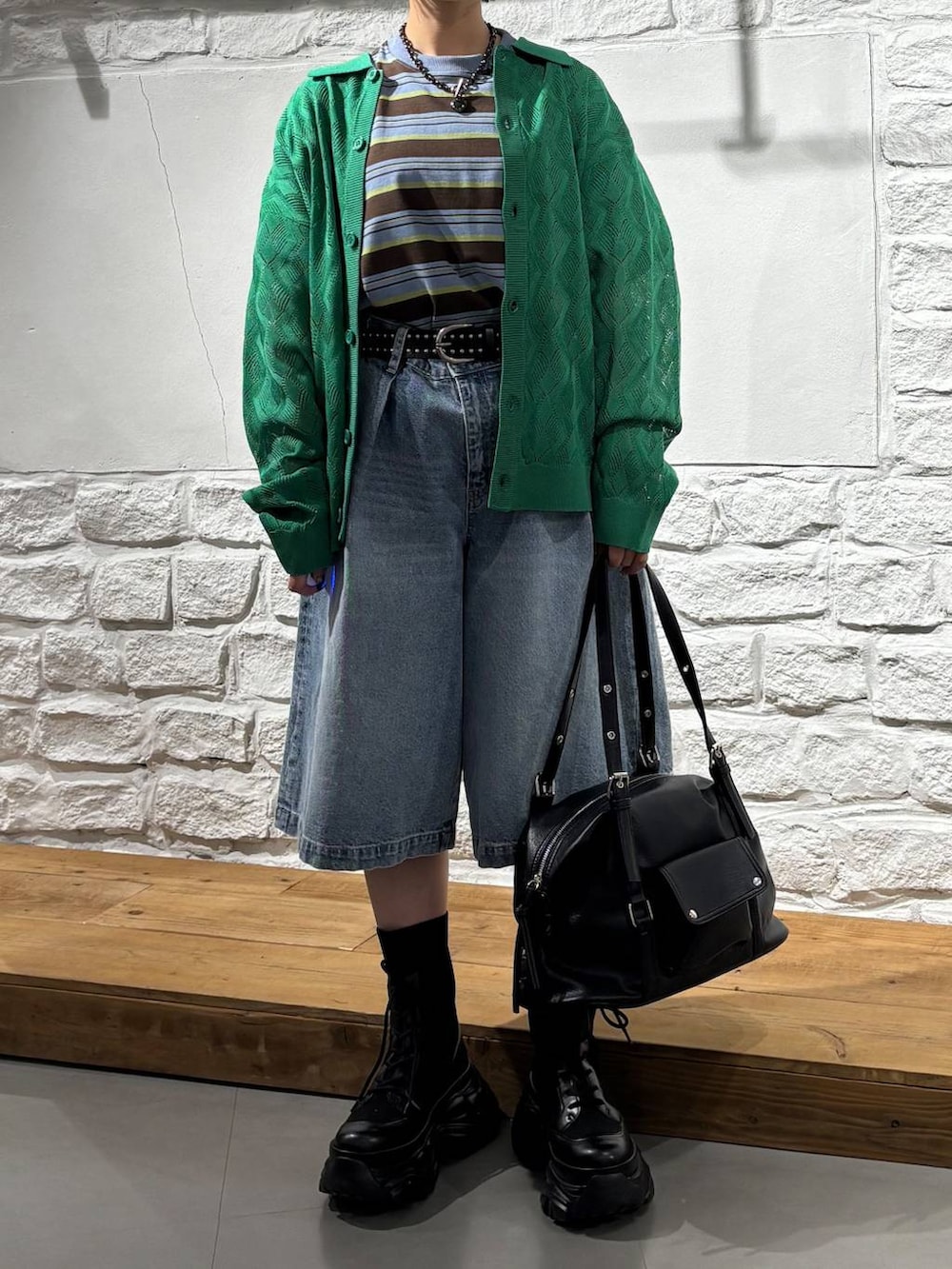 ブラック系のブーツ、ブルー系のデニムパンツ、ブラウン系のTシャツ/カットソーを着用したレディースの春コーディネートの3枚目の写真