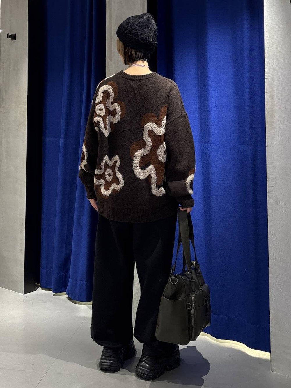 ブラック系のスニーカー、グリーン系のボストンバッグ、ブラウン系のニット/セーターを着用したレディースの冬コーディネートの5枚目の写真