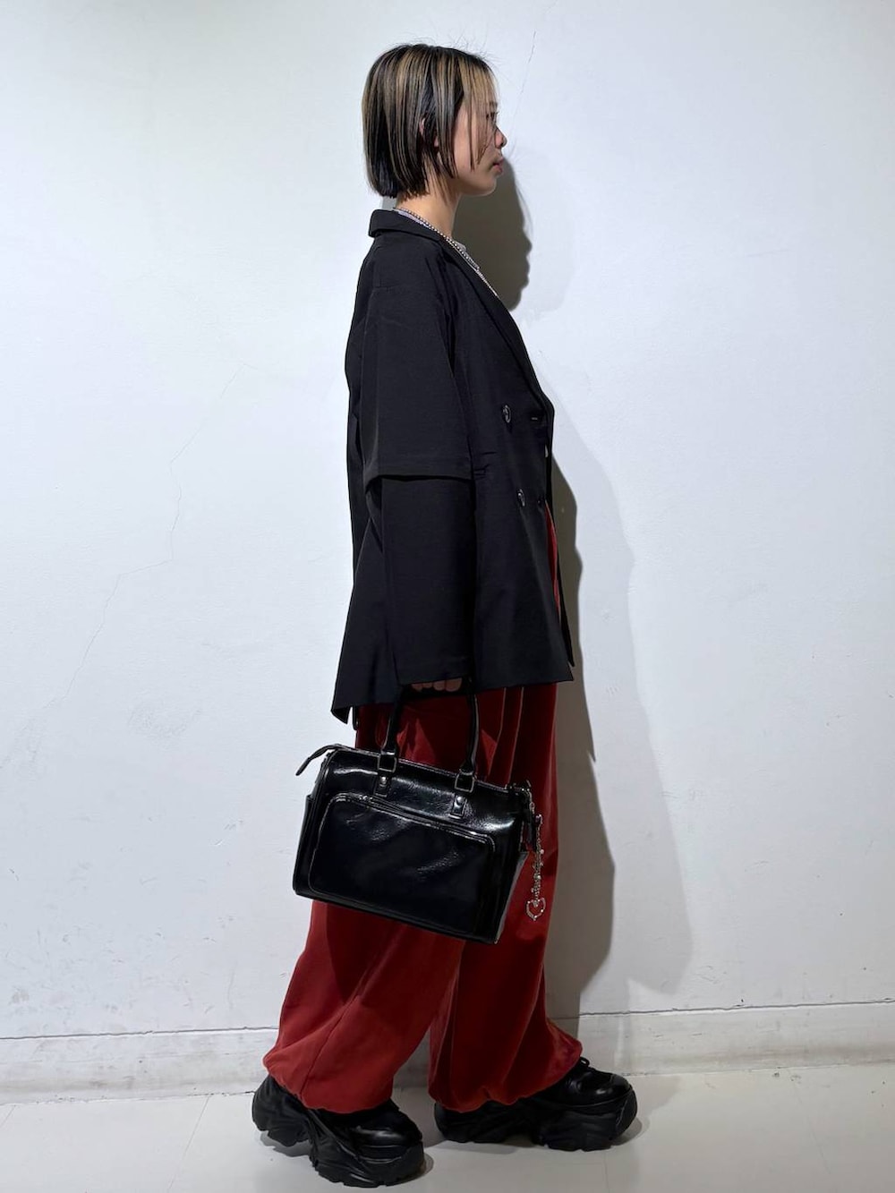 ブラック系のスニーカー、ブラック系のショルダーバッグ、ブラック系のテーラードジャケットを着用したレディースの春コーディネートの4枚目の写真