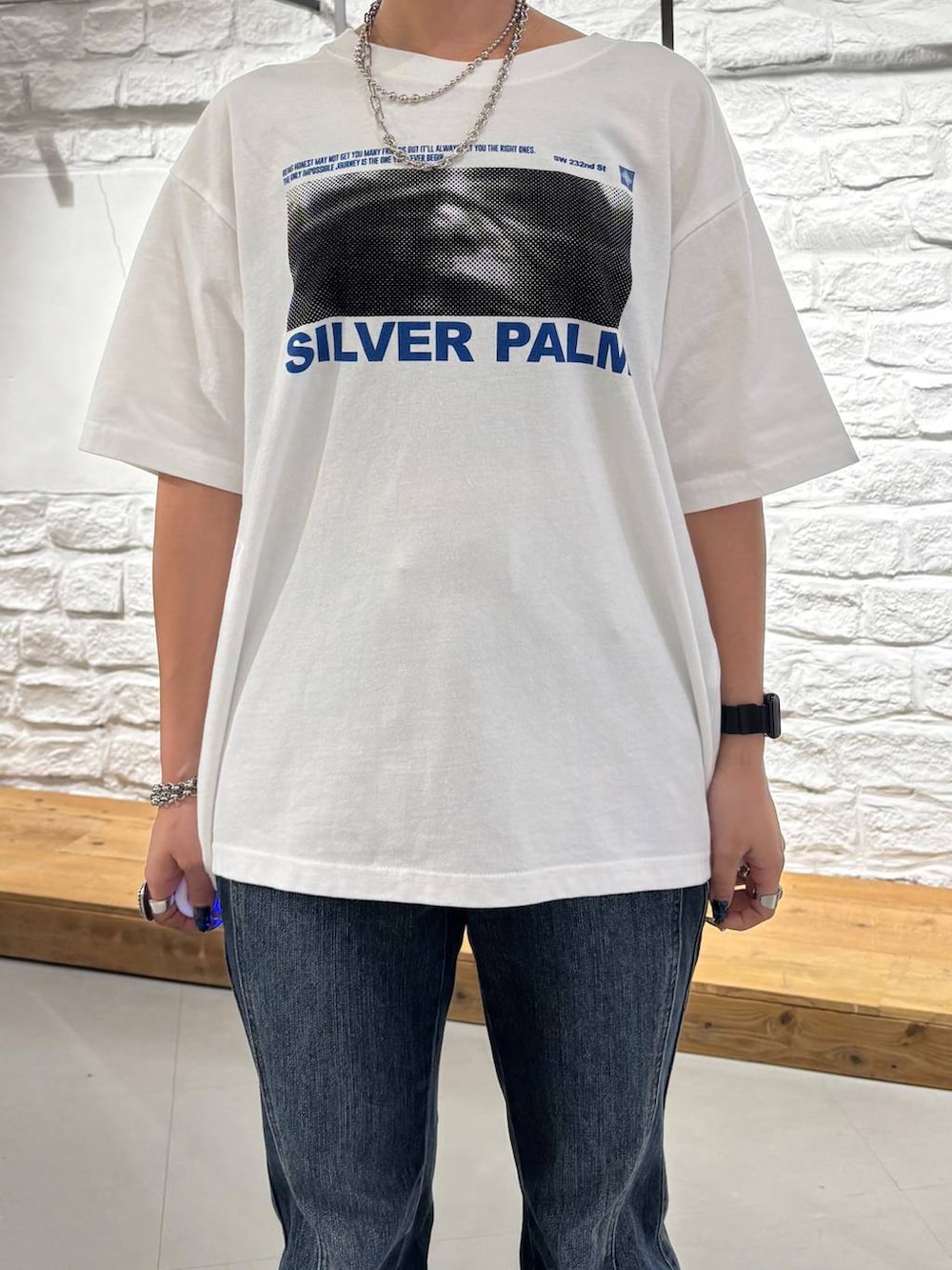 ホワイト系のTシャツ/カットソー、ブルー系のデニムパンツ、ブラック系のショルダーバッグを着用したレディースの夏コーディネートの4枚目の写真