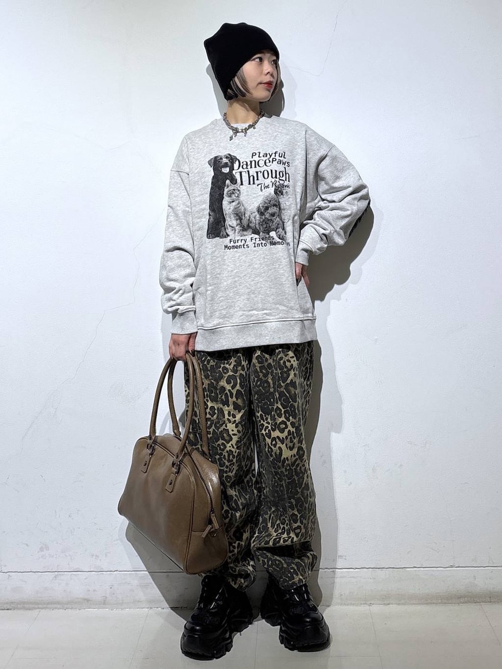 ブラック系のブーツ、ベージュ系のボストンバッグ、グレー系のスウェットを着用したレディースの冬コーディネートの3枚目の写真