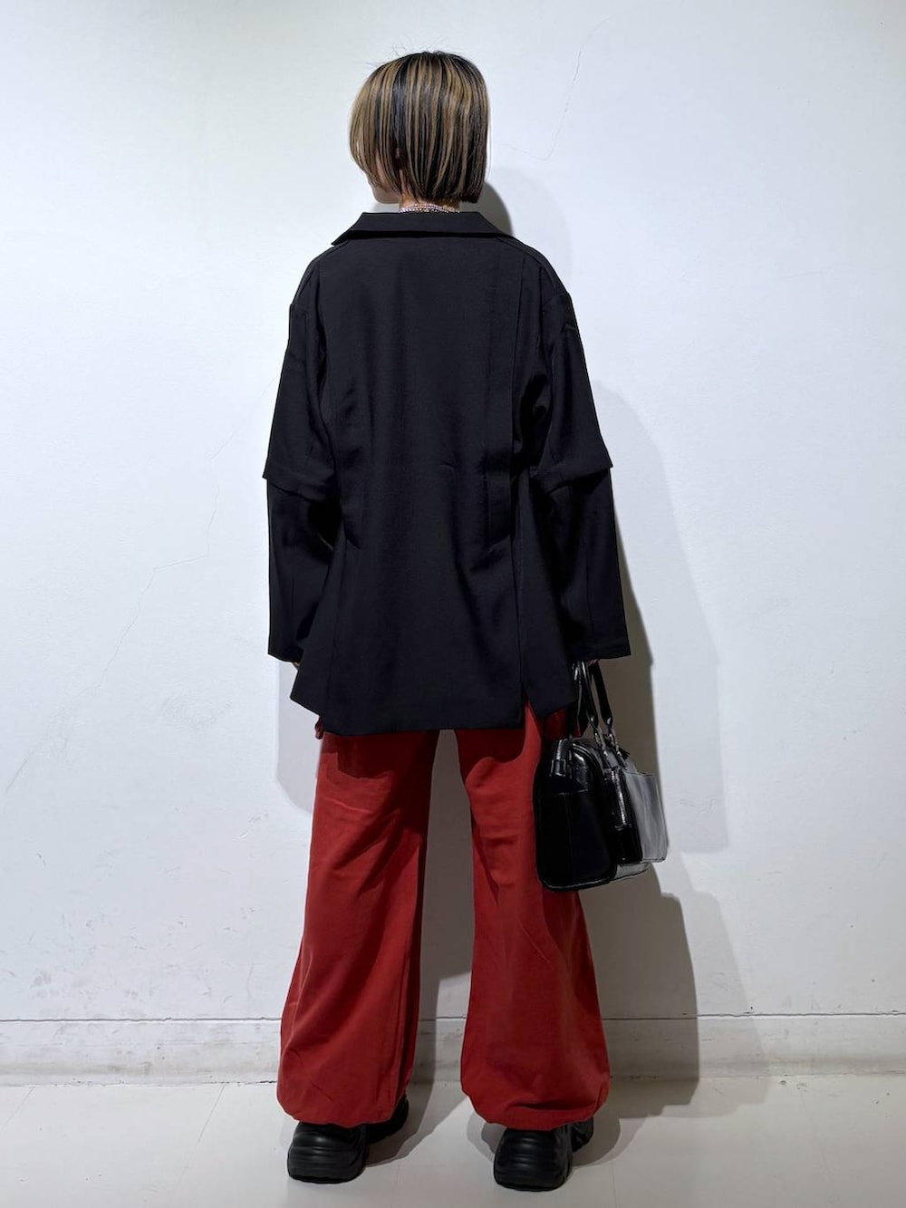 ブラック系のスニーカー、ブラック系のショルダーバッグ、ブラック系のテーラードジャケットを着用したレディースの春コーディネートの5枚目の写真