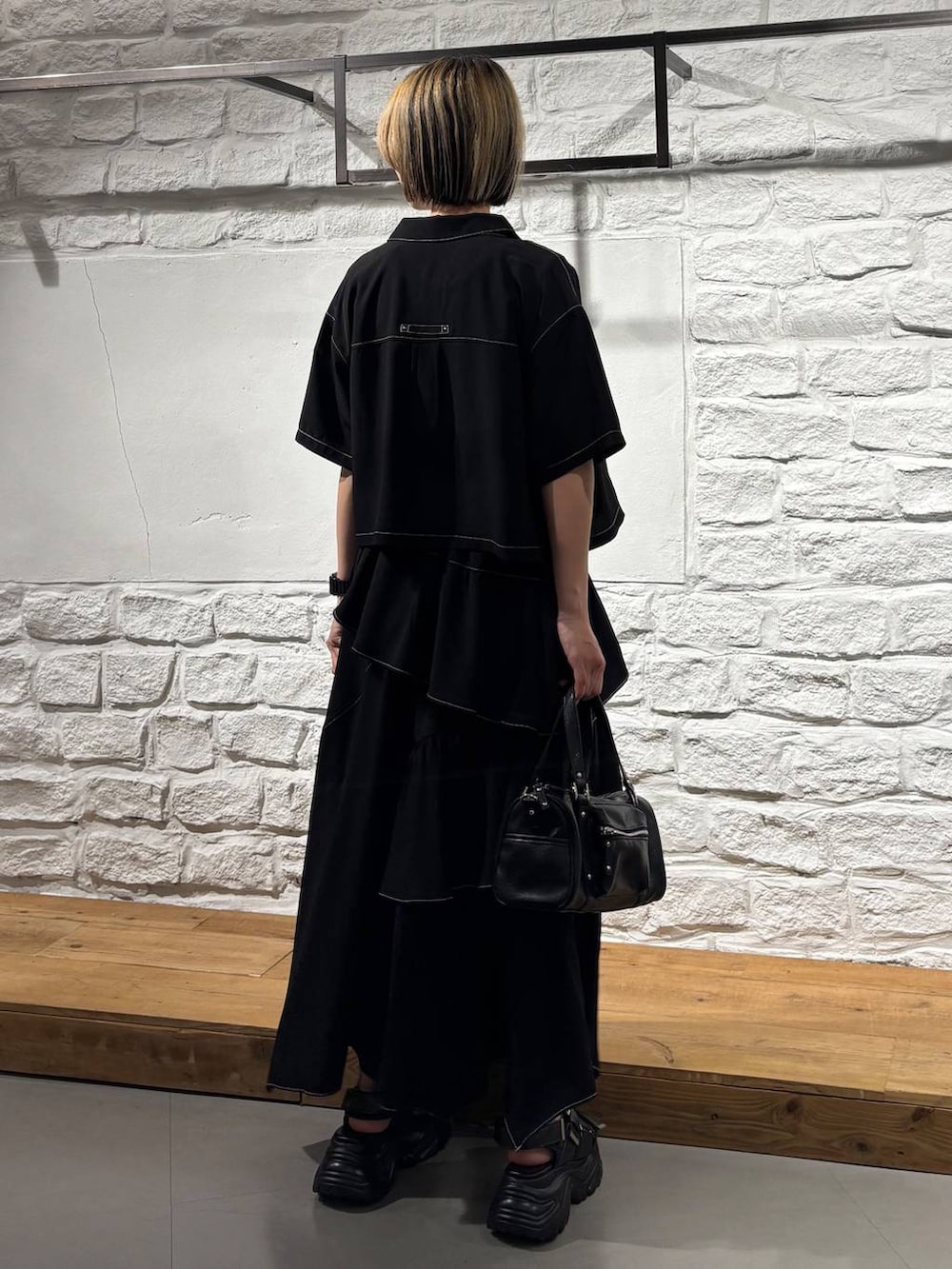 ブラック系のショルダーバッグ、ブラック系のスカート、ブラック系のシャツ/ブラウスを着用したレディースの夏コーディネートの6枚目の写真
