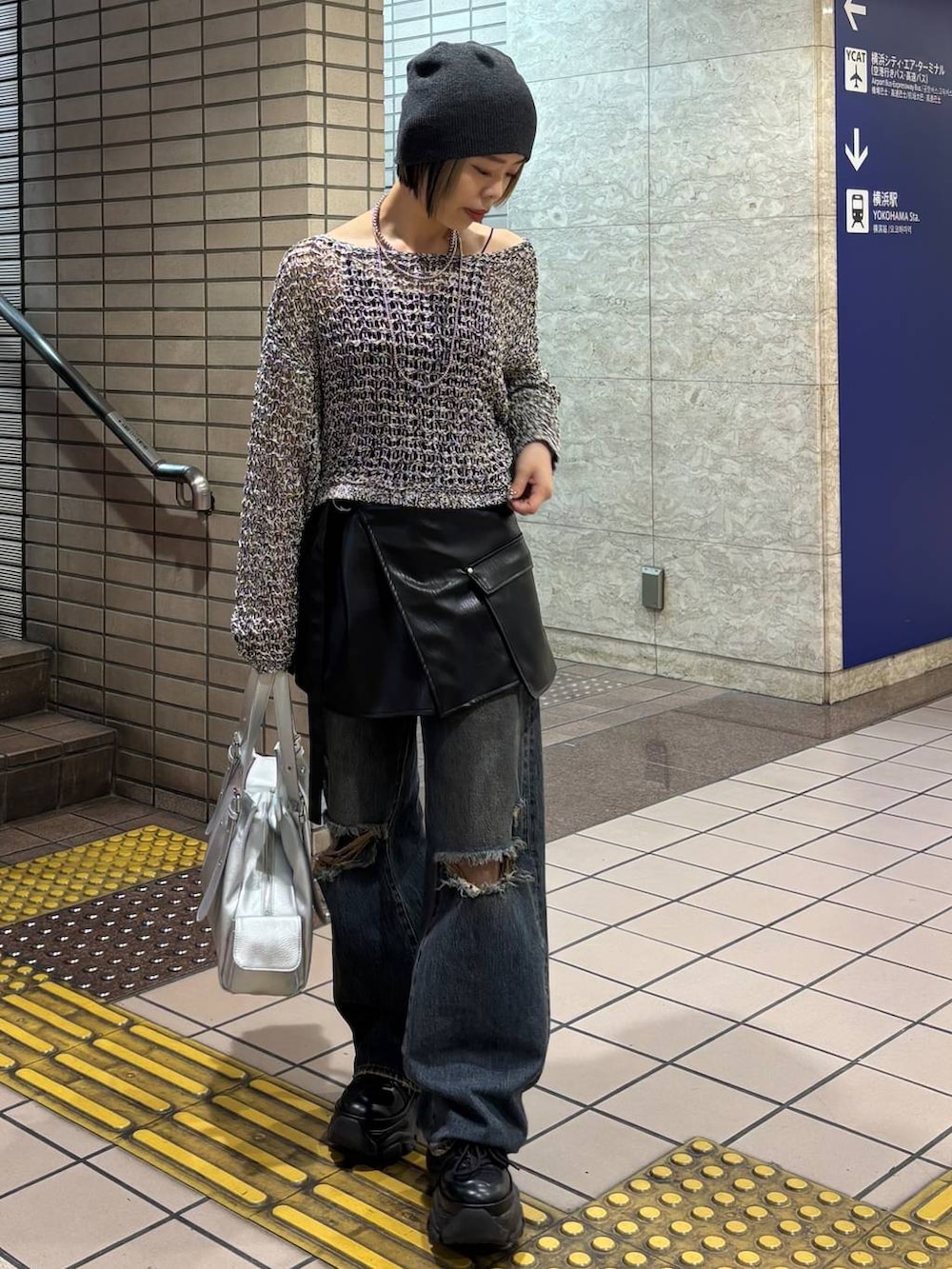 ブラック系のスニーカー、ブラック系のニット/セーター、シルバー系のハンドバッグを着用したレディースの春コーディネートの3枚目の写真