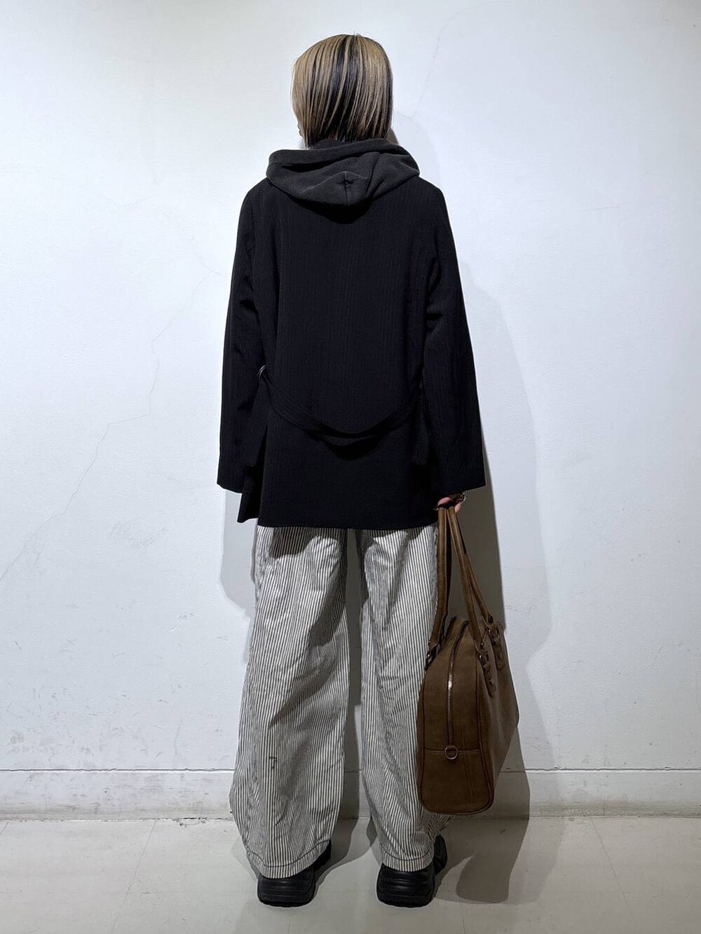 ブラック系のブーツ、ベージュ系のボストンバッグ、ブラック系のTシャツ/カットソーを着用したレディースの冬コーディネートの6枚目の写真