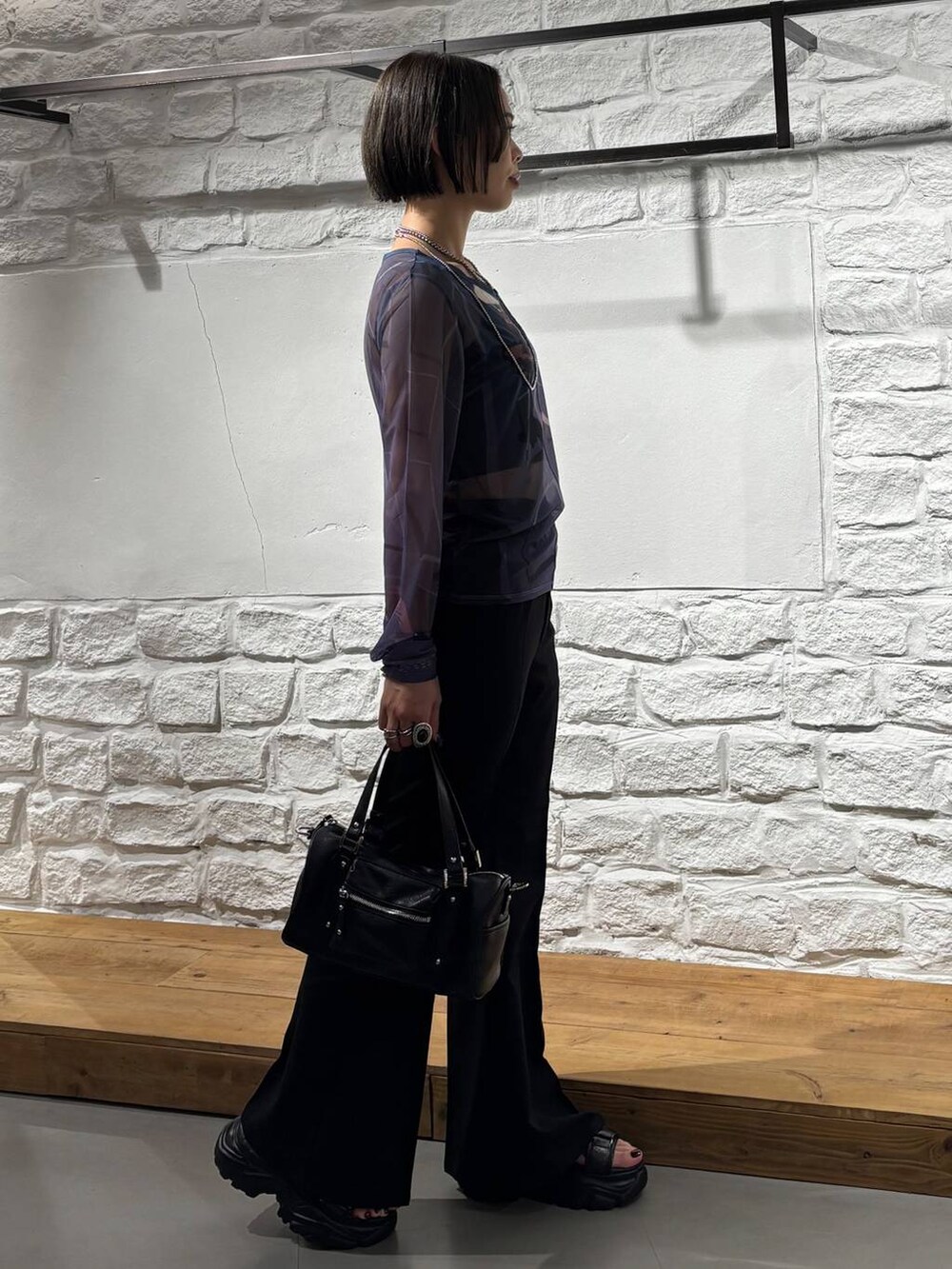 ブラック系のショルダーバッグ、ブラック系のスラックス、ブルー系のTシャツ/カットソーを着用したレディースの夏コーディネートの5枚目の写真
