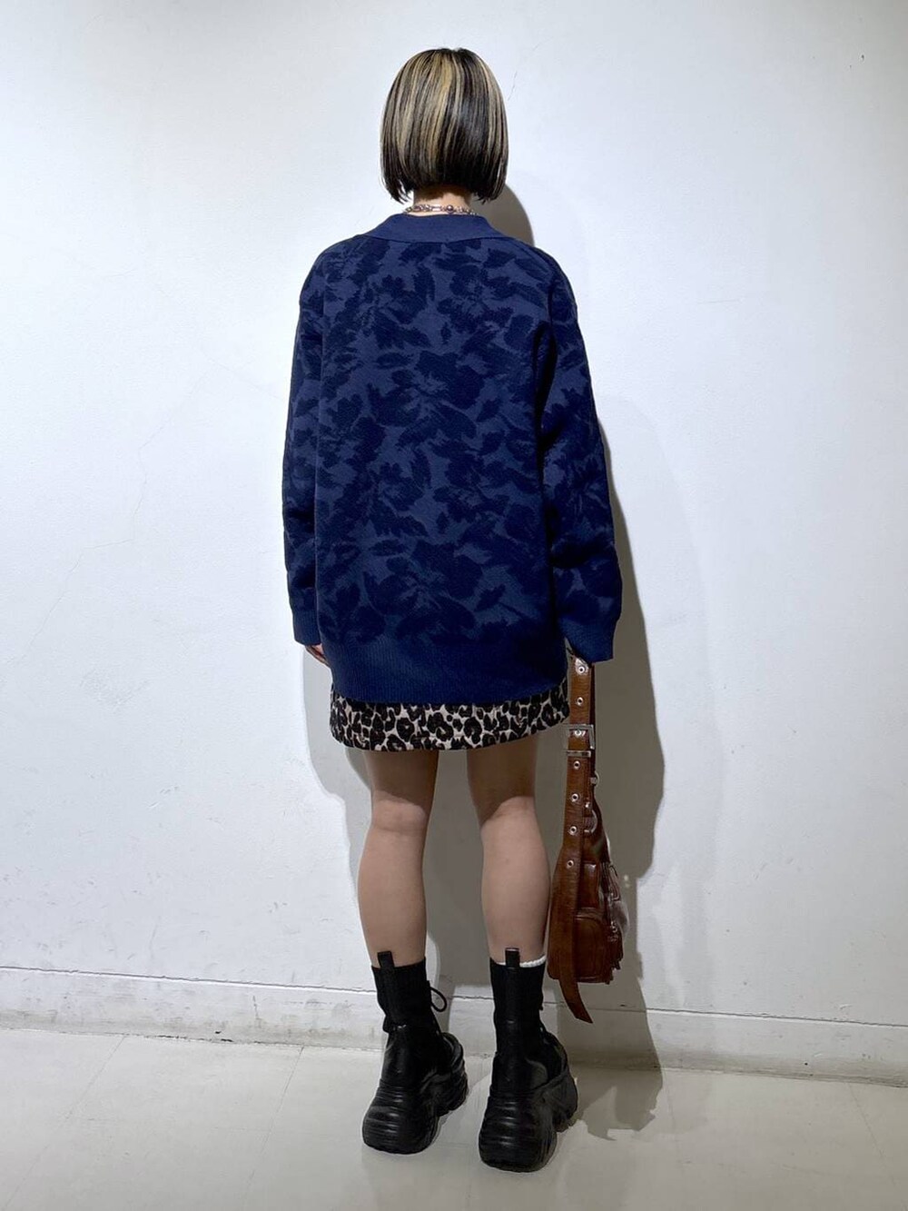 ブラック系のブーツ、ホワイト系のTシャツ/カットソー、ブラウン系のスカートを着用したレディースの秋コーディネートの4枚目の写真