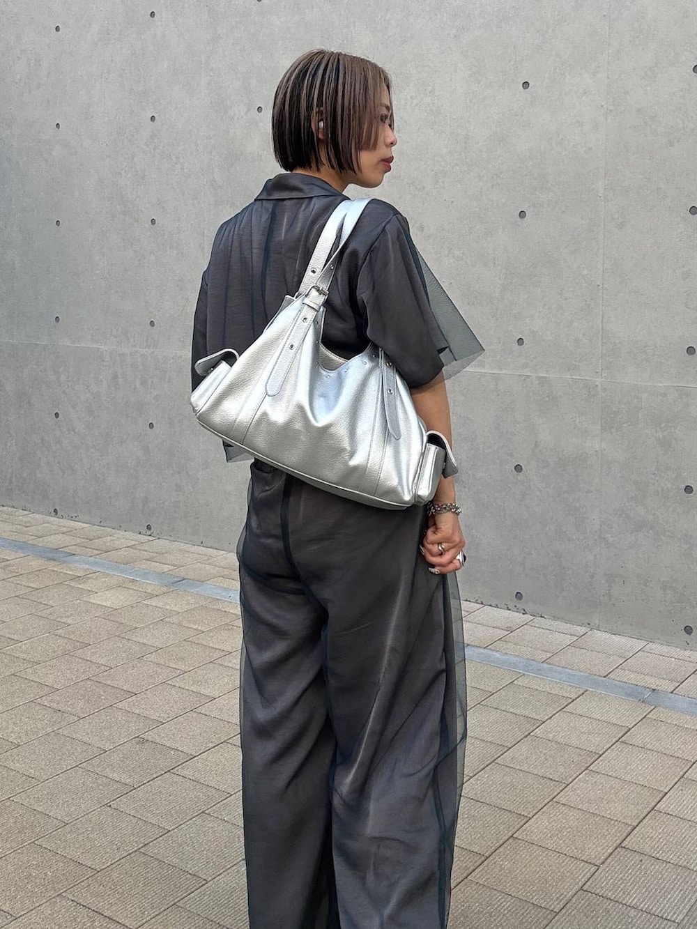 ブラック系のキャミソール、シルバー系のハンドバッグ、グレー系のその他パンツを着用したレディースの春コーディネートの8枚目の写真