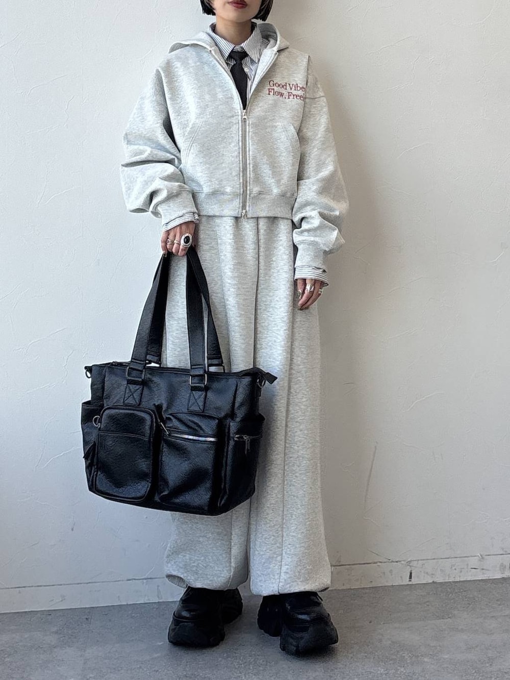 ブラック系のスニーカー、ブラック系のボストンバッグ、グレー系のパーカーを着用したレディースの冬コーディネートの7枚目の写真