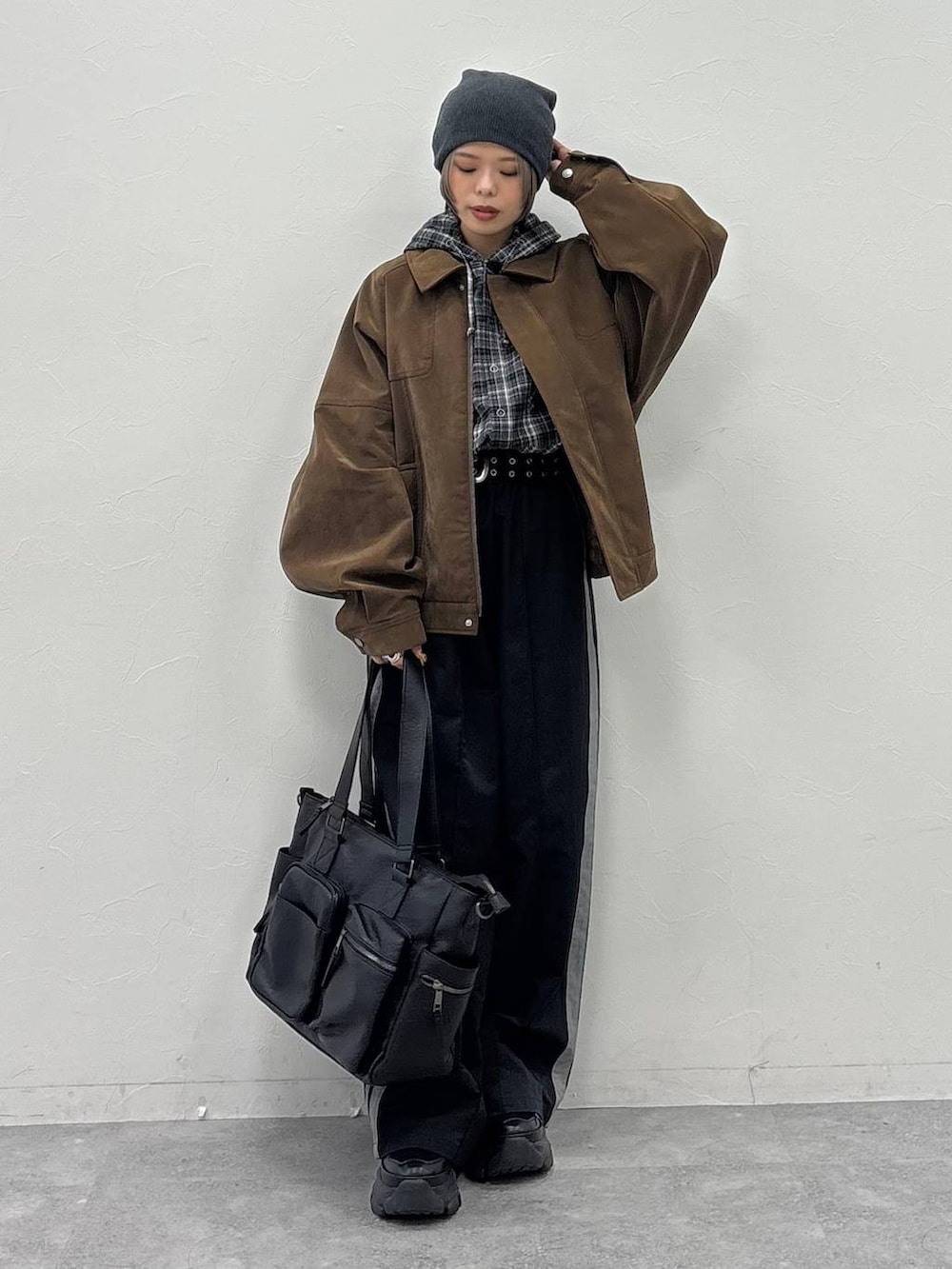 ブラック系のスニーカー、グリーン系のボストンバッグ、ブラウン系のブルゾンを着用したレディースの冬コーディネートの3枚目の写真