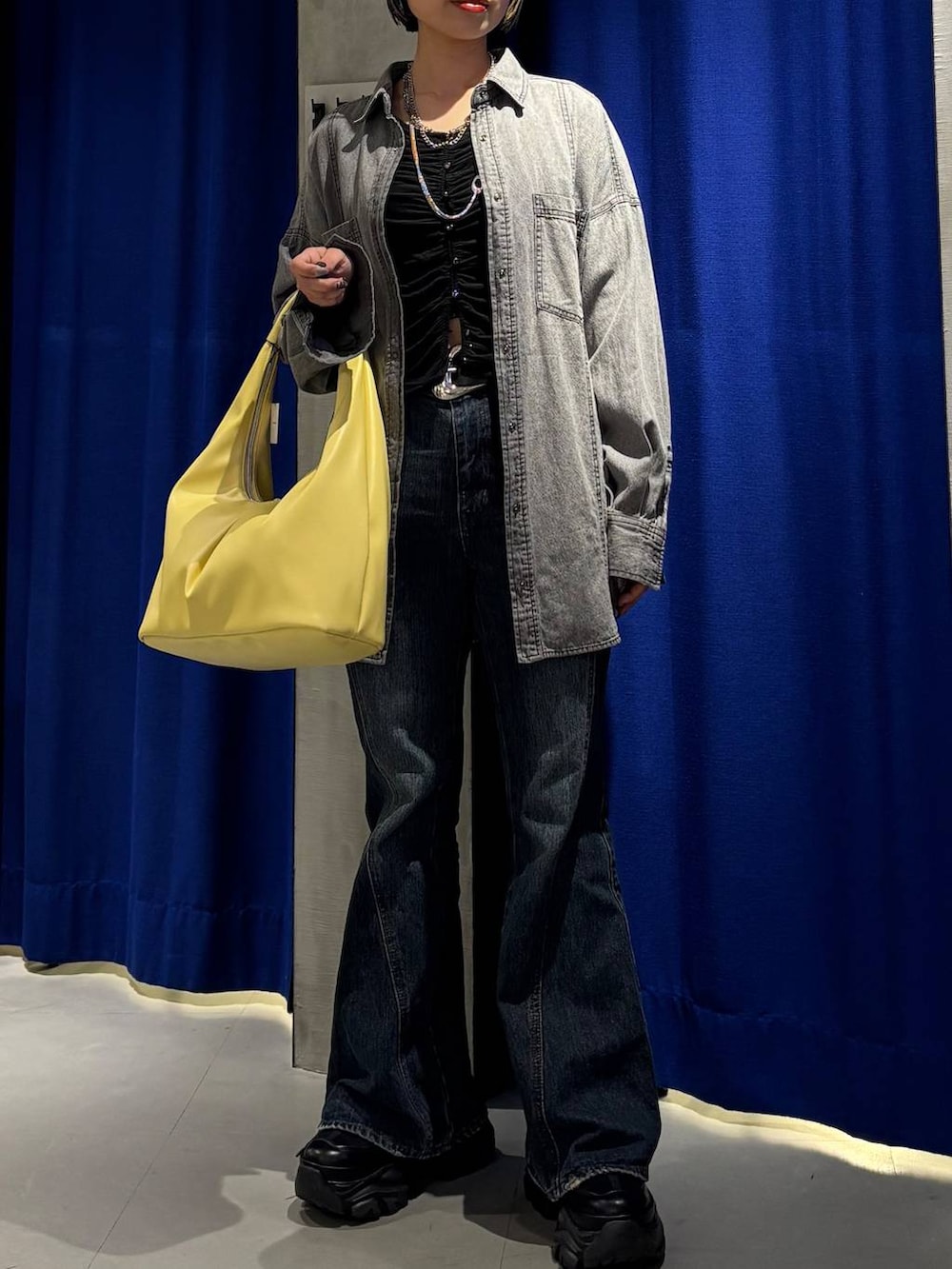 ブラック系のスニーカー、ブルー系のデニムパンツ、ブラック系のシャツ/ブラウスを着用したレディースの春コーディネートの3枚目の写真