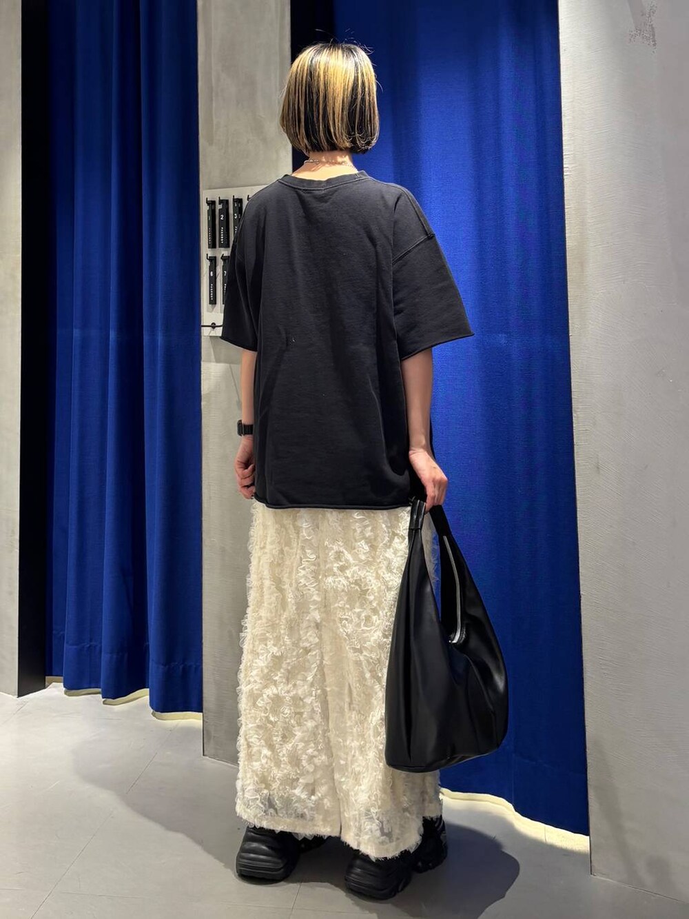 ブラック系のスニーカー、ブラック系のトートバッグ、ブラック系のTシャツ/カットソーを着用したレディースの春コーディネートの5枚目の写真