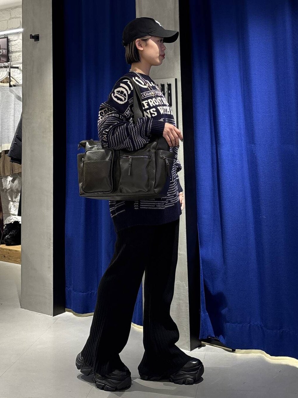 ブラック系のブーツ、グリーン系のボストンバッグ、ブラック系のその他パンツを着用したレディースの冬コーディネートの3枚目の写真