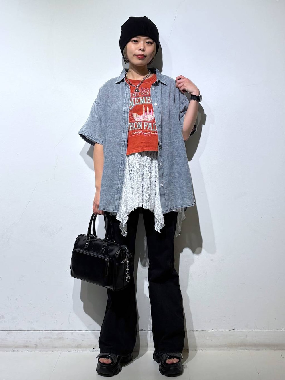 ブラック系のデニムパンツ、ブラック系のショルダーバッグ、ブルー系のシャツ/ブラウスを着用したレディースの春コーディネートの2枚目の写真