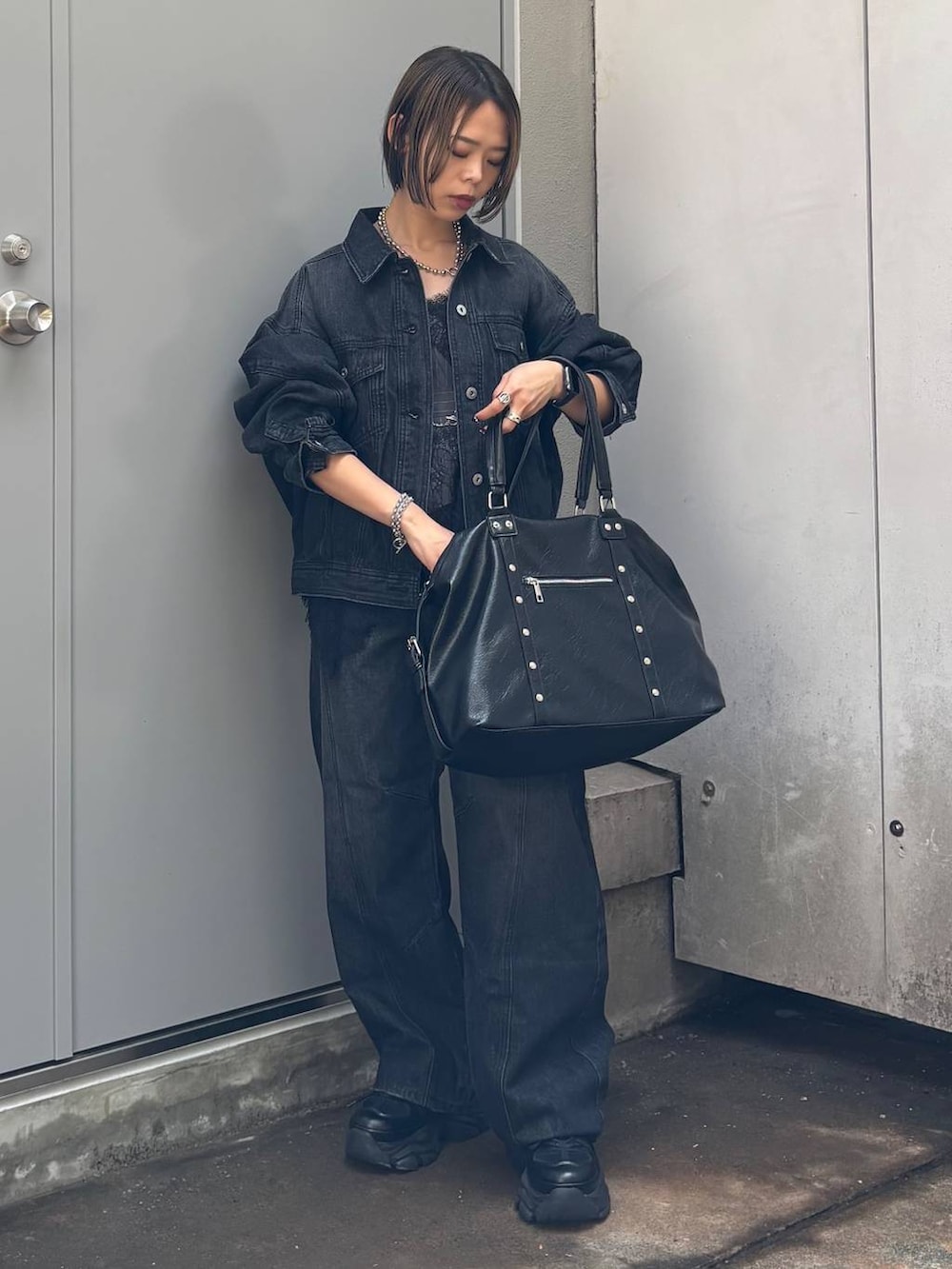ブラック系のボストンバッグ、ブラック系のデニムパンツ、ブラック系のデニムジャケットを着用したレディースの夏コーディネートの5枚目の写真