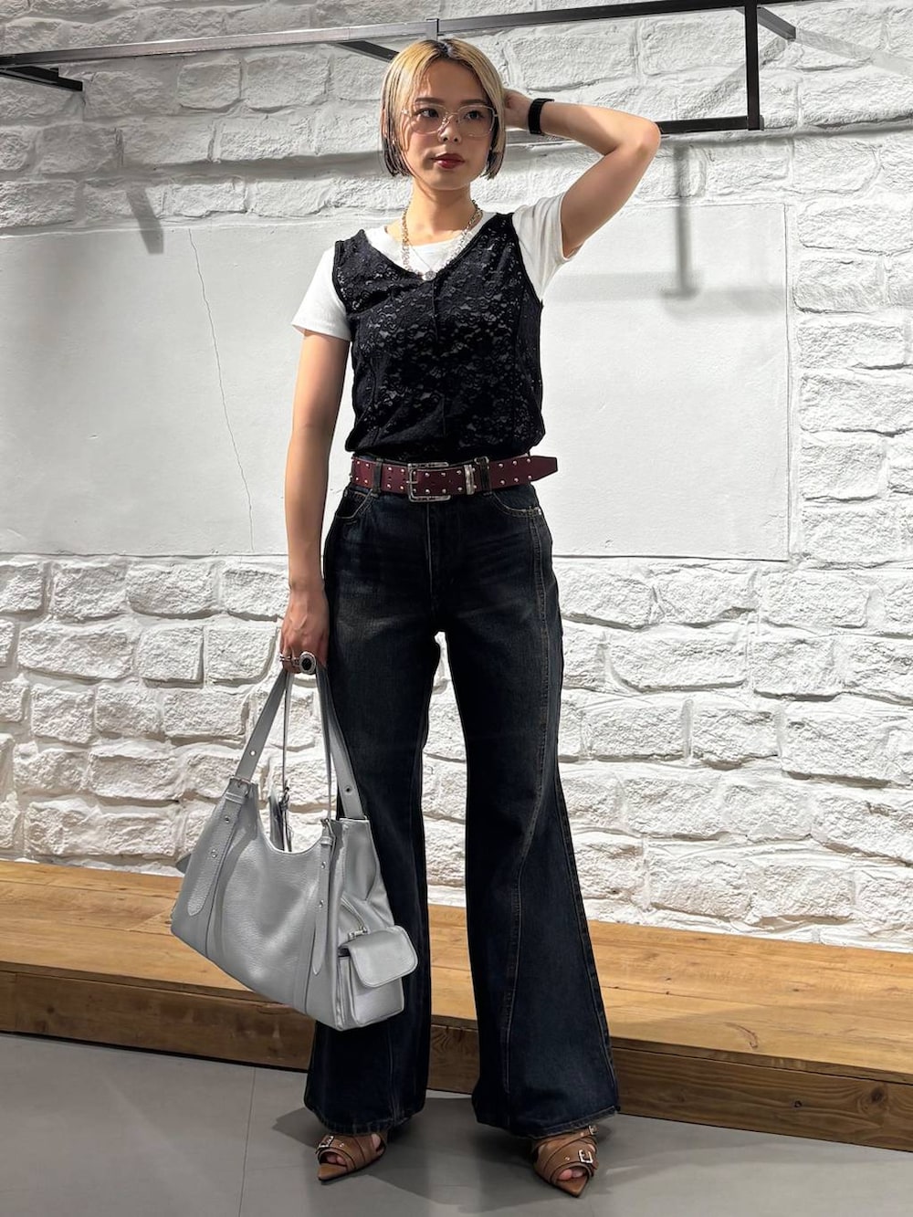 ブルー系のデニムパンツ、イエロー系のサンダル、シルバー系のハンドバッグを着用したレディースの春コーディネートの2枚目の写真
