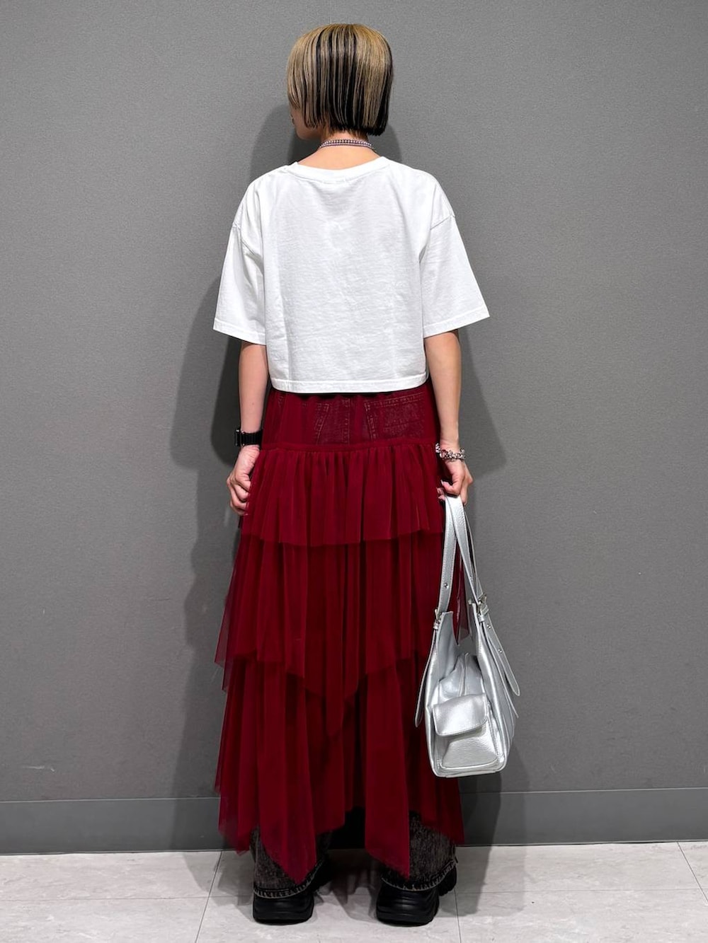 ブラック系のスニーカー、ブラック系のデニムパンツ、ホワイト系のTシャツ/カットソーを着用したレディースの春コーディネートの5枚目の写真