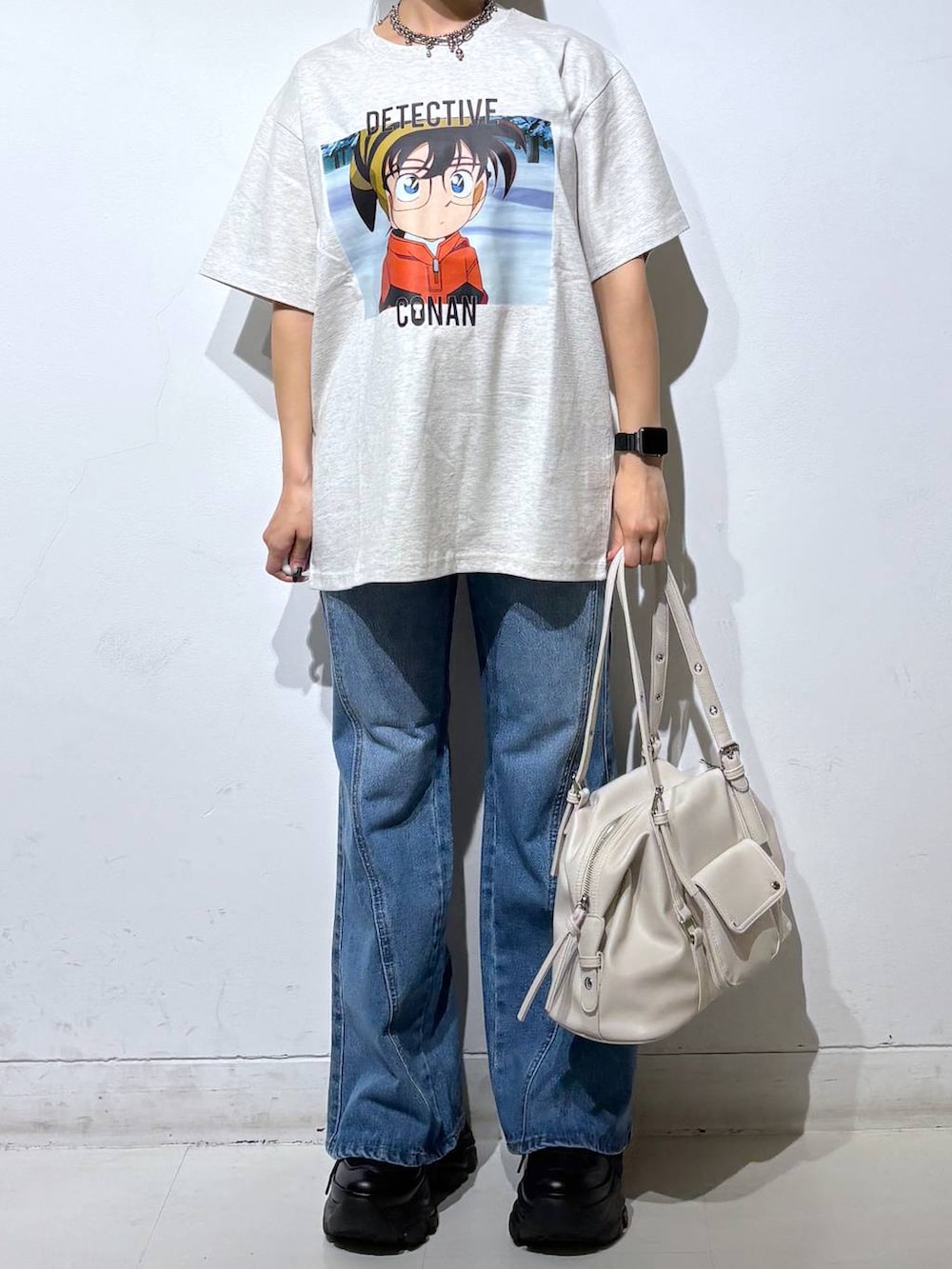 ブラック系のスニーカー、ブルー系のデニムパンツ、ホワイト系のボストンバッグを着用したレディースの春コーディネートの3枚目の写真