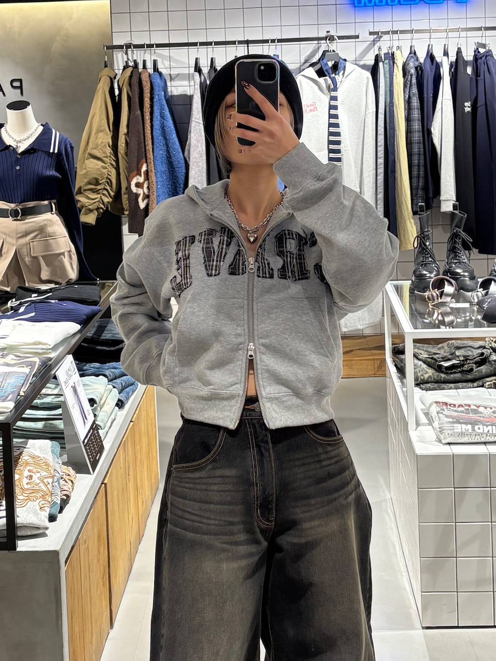 ブラック系のブーツ、ブラック系のデニムパンツ、グレー系のパーカーを着用したレディースの冬コーディネートの3枚目の写真