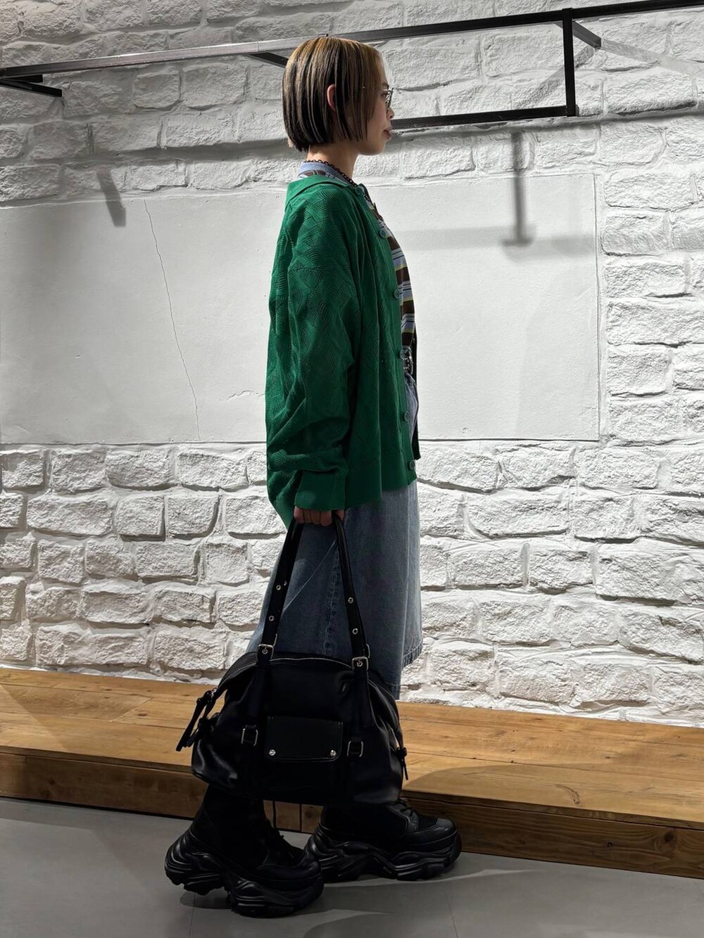 ブラック系のブーツ、ブルー系のデニムパンツ、ブラウン系のTシャツ/カットソーを着用したレディースの春コーディネートの4枚目の写真