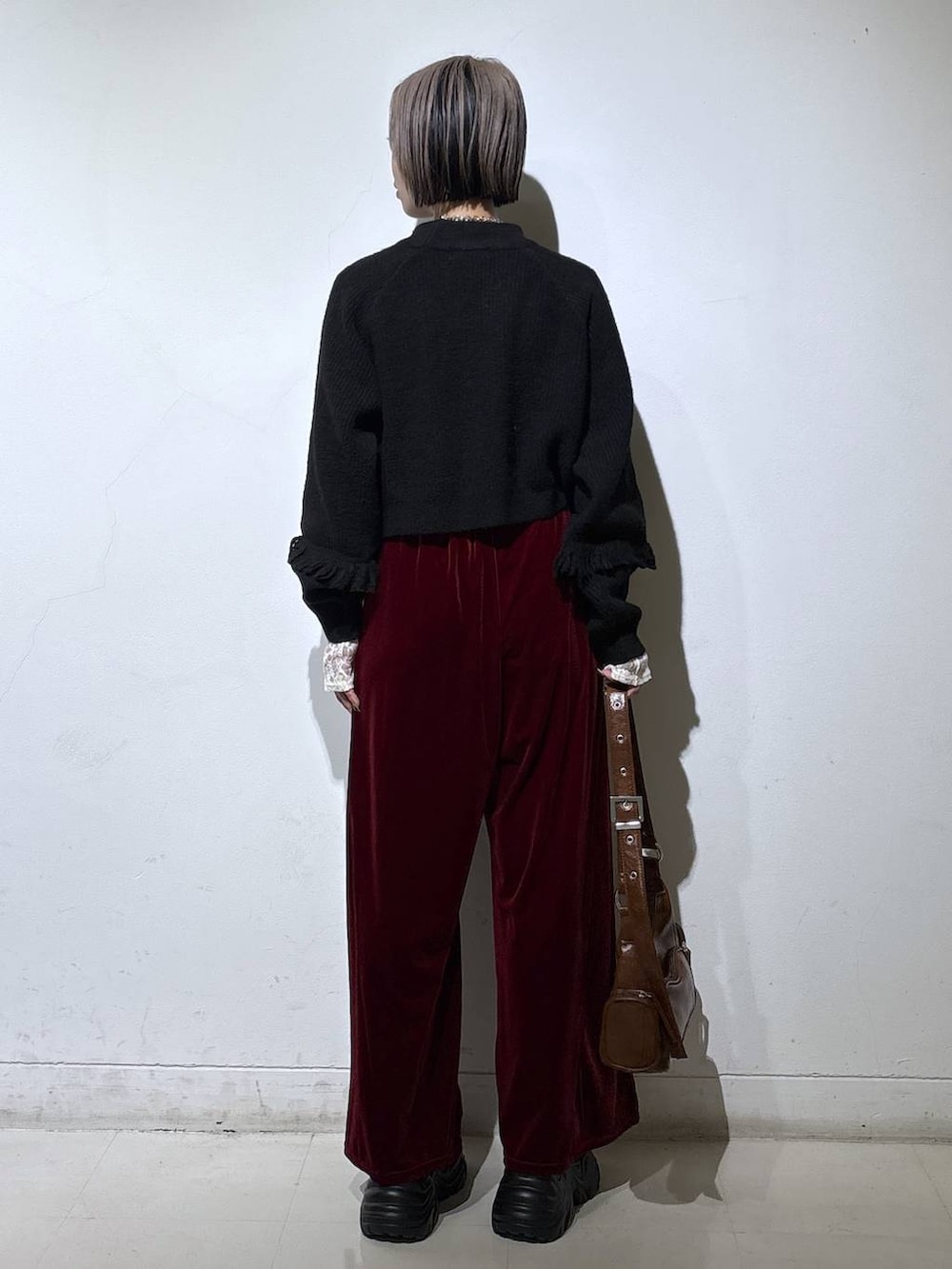 ブラック系のブーツ、ホワイト系のTシャツ/カットソー、ブラウン系のショルダーバッグを着用したレディースの冬コーディネートの4枚目の写真