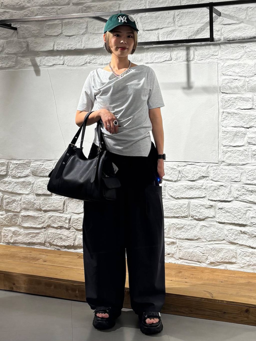 ブラック系のその他パンツ、グレー系のサンダル、ブルー系のハンドバッグを着用したレディースの春コーディネートの2枚目の写真