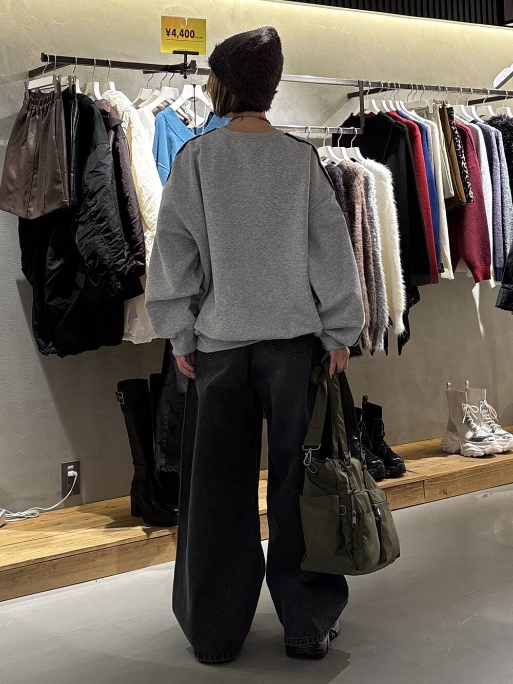 ブラック系のスニーカー、ブラック系のデニムパンツ、グリーン系のボストンバッグを着用したレディースの冬コーディネートの4枚目の写真