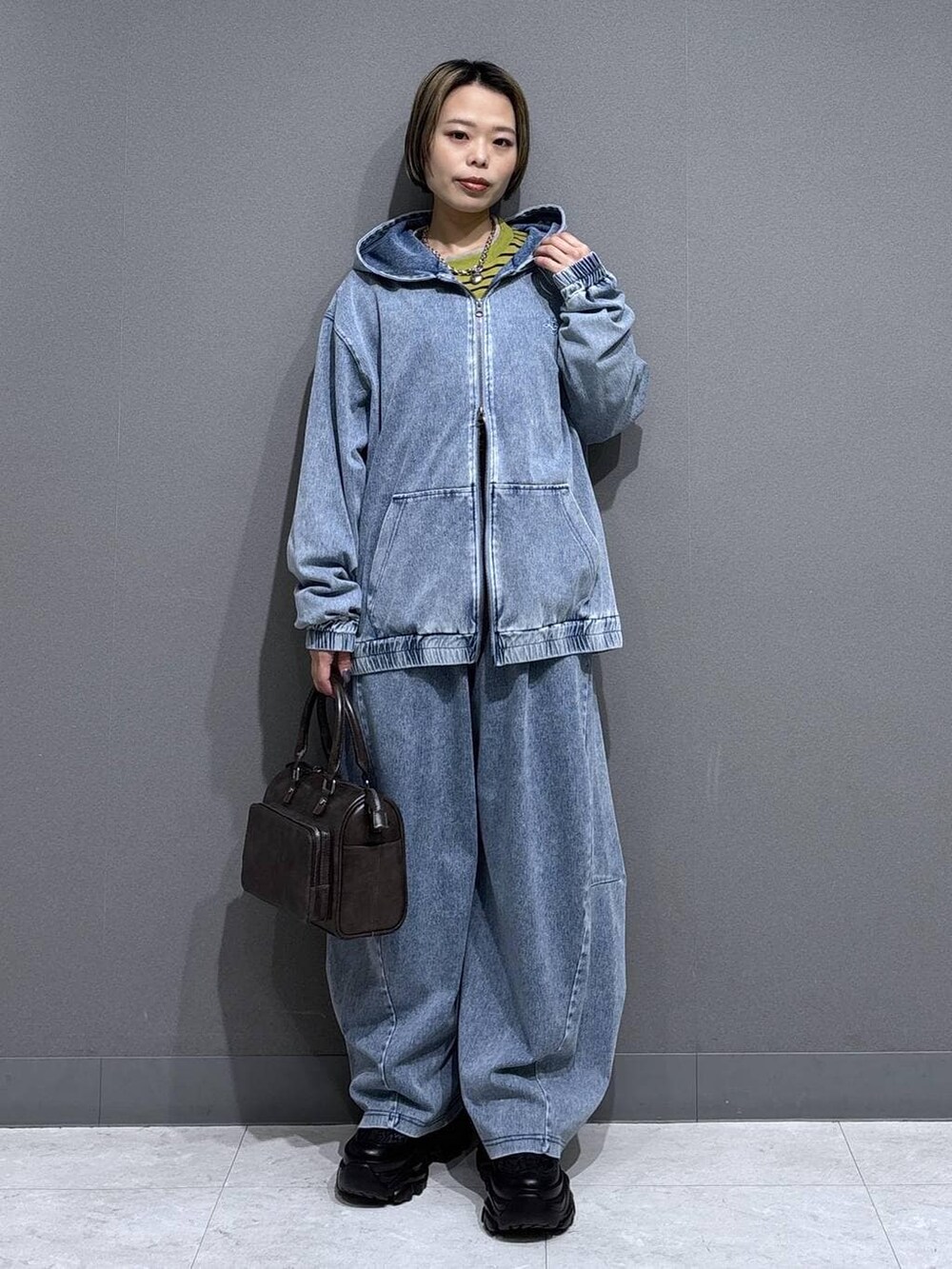 ブラック系のスニーカー、グレー系のショルダーバッグ、イエロー系のTシャツ/カットソーを着用したレディースの春コーディネートの3枚目の写真