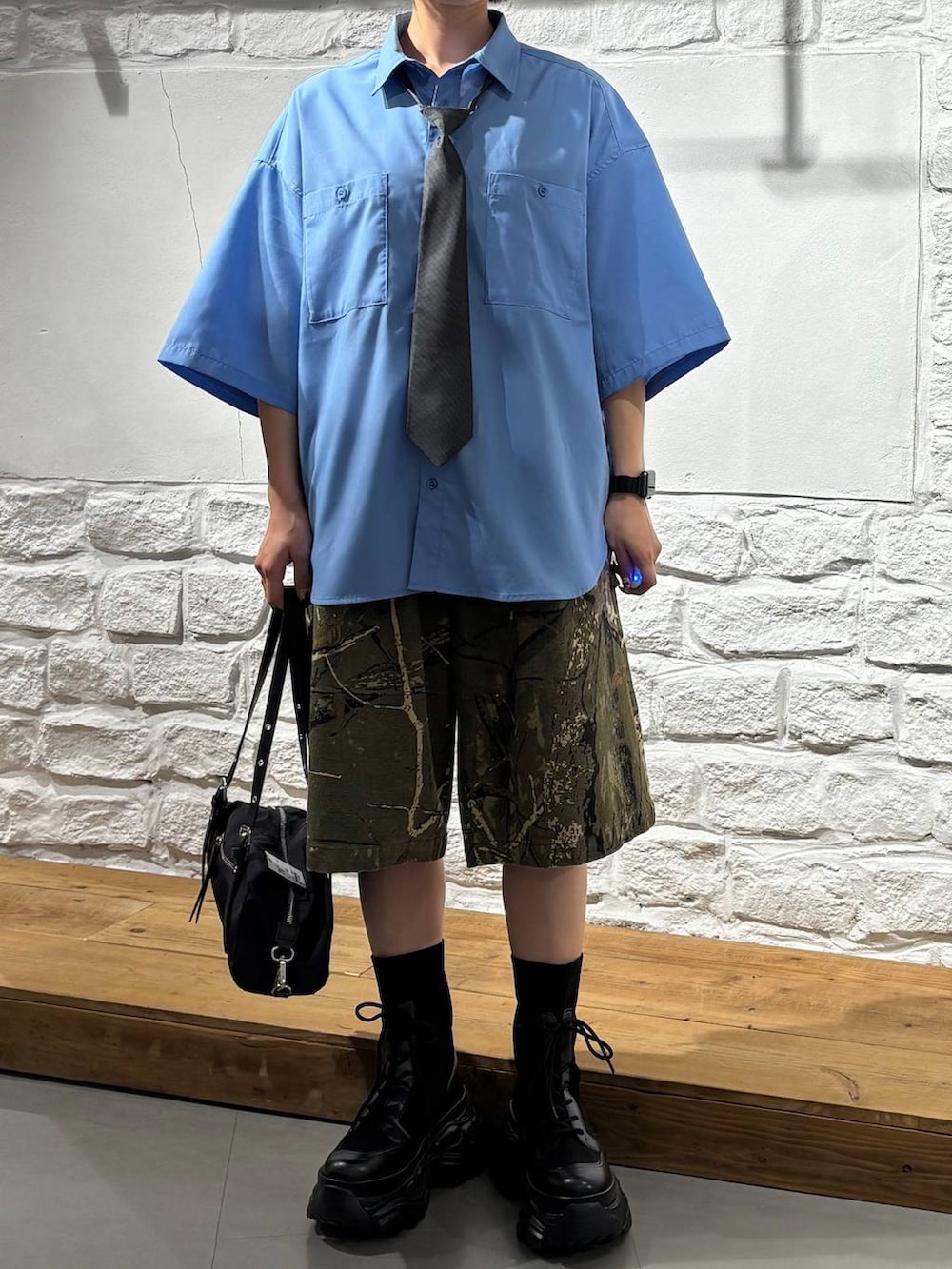 ブラック系のブーツ、その他のデニムパンツ、ブラック系のトートバッグを着用したレディースの春コーディネートの3枚目の写真