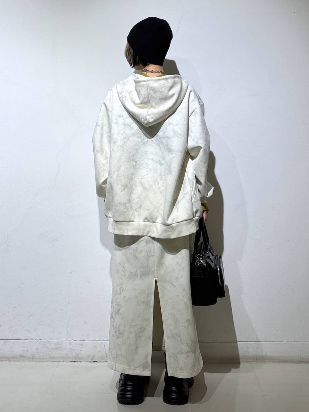 ブラック系のブーツ、ホワイト系のパーカー、ホワイト系のスカートを着用したレディースの冬コーディネートの5枚目の写真