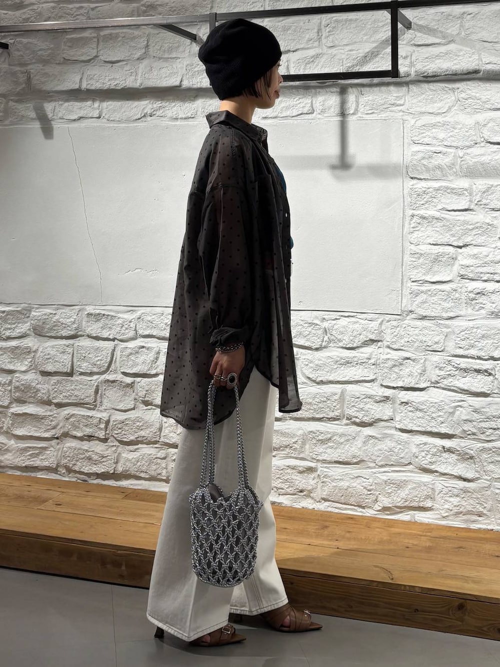 ホワイト系のデニムパンツ、シルバー系のショルダーバッグ、イエロー系のサンダルを着用したレディースの春コーディネートの4枚目の写真