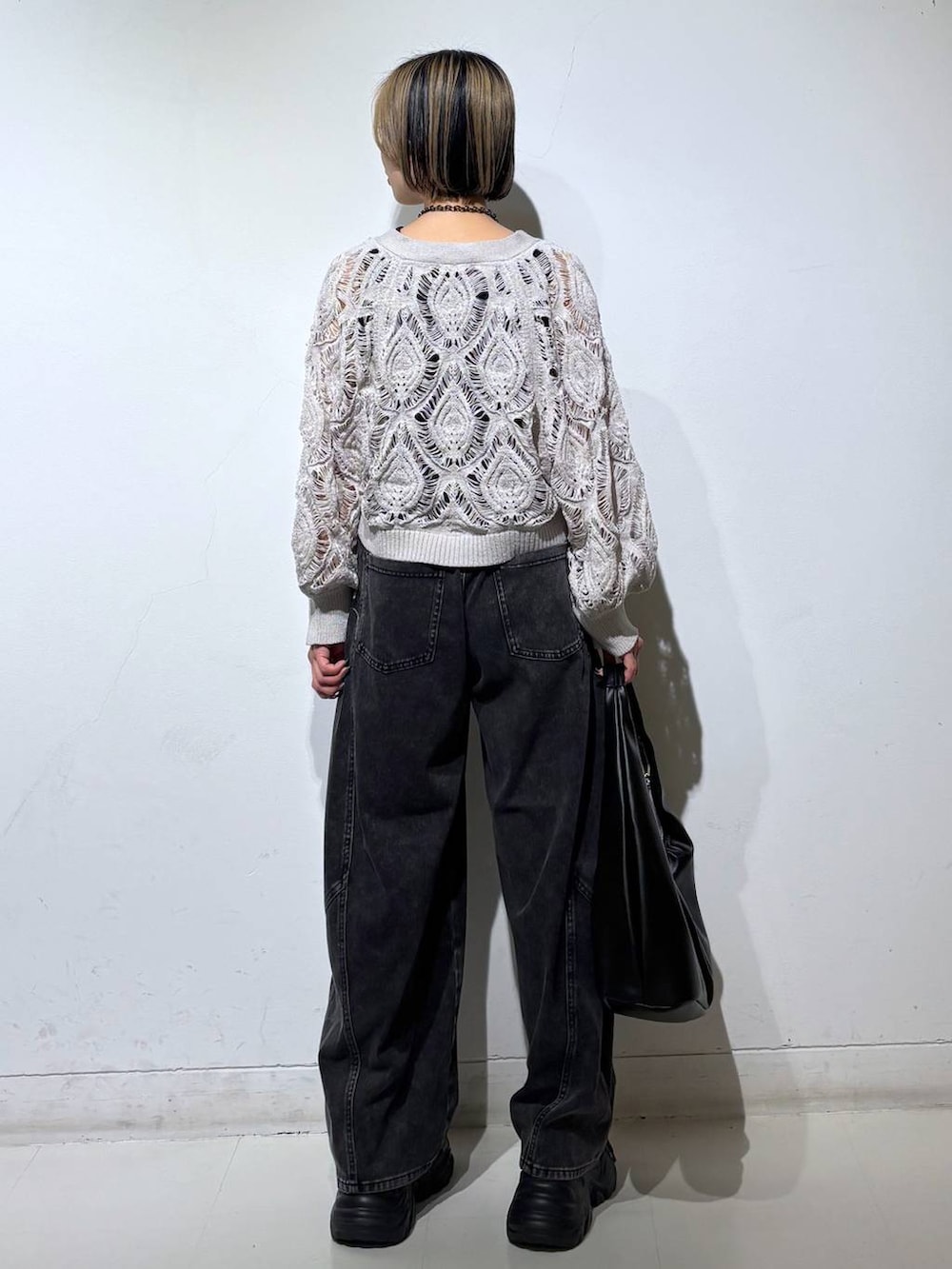 ブラック系のスニーカー、ベージュ系のカーディガン/ボレロ、ブラック系のデニムパンツを着用したレディースの春コーディネートの5枚目の写真