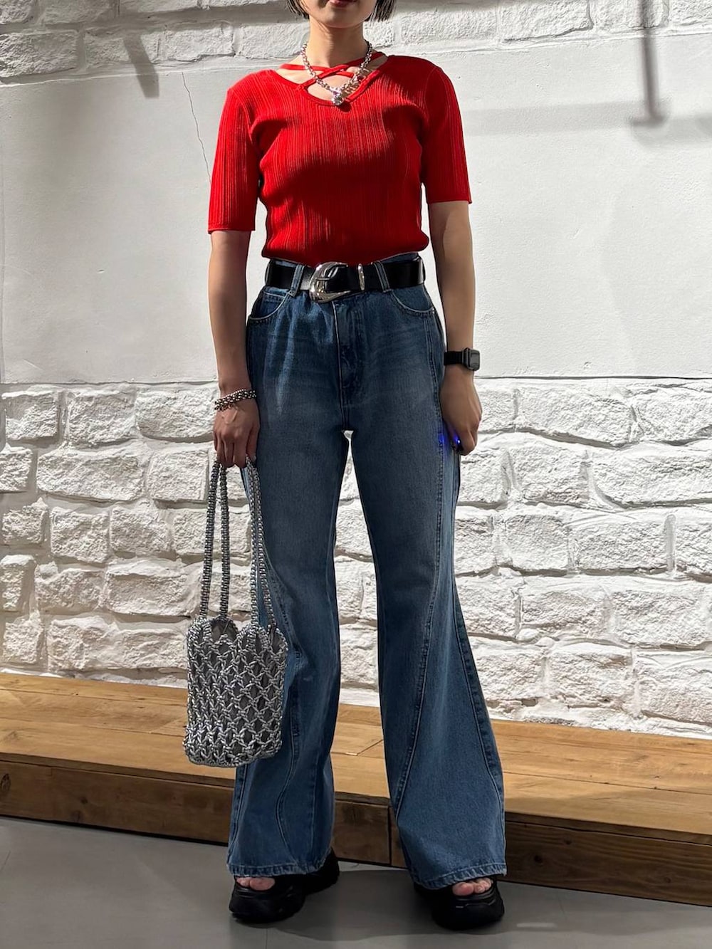 ブルー系のデニムパンツ、ブラック系のサンダル、レッド系のニット/セーターを着用したレディースの春コーディネートの3枚目の写真