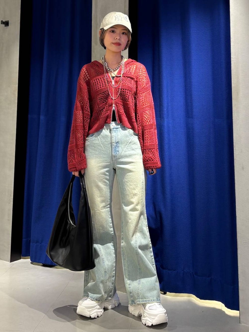 ホワイト系のスニーカー、ブラック系のキャミソール、ブルー系のデニムパンツを着用したレディースの春コーディネートの2枚目の写真