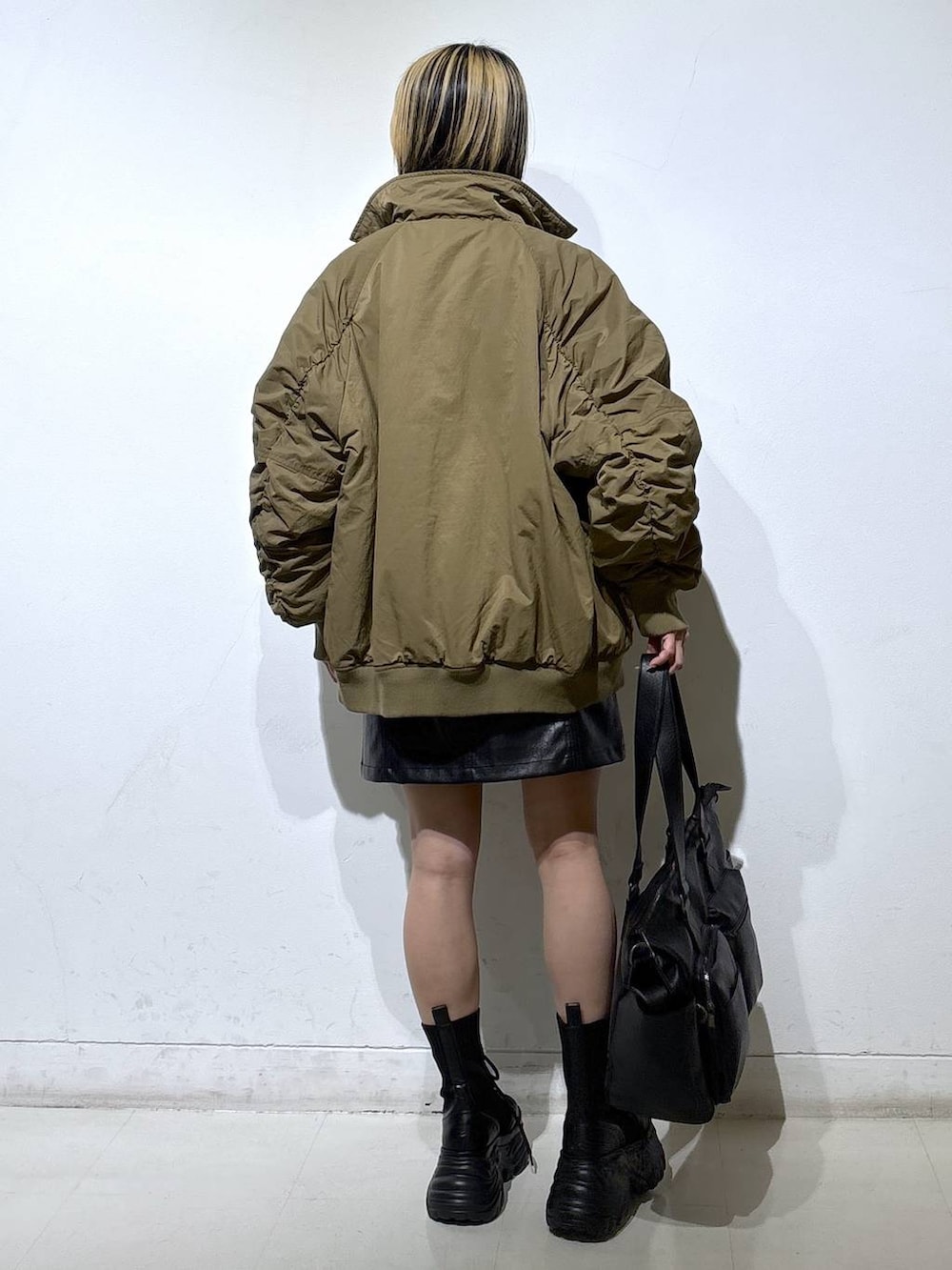 ブラック系のブーツ、ブラック系のボストンバッグ、ブラック系のスカートを着用したレディースの冬コーディネートの4枚目の写真