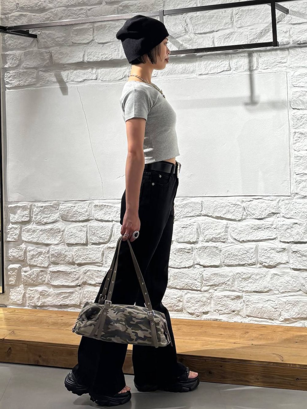 ブラック系のデニムパンツ、グレー系のTシャツ/カットソー、ブラック系のサンダルを着用したレディースの春コーディネートの4枚目の写真