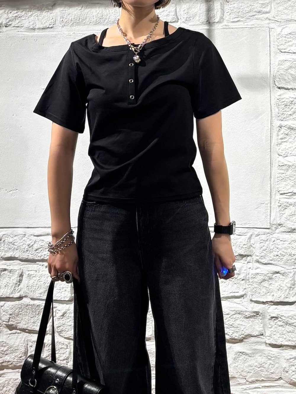 ブラック系のデニムパンツ、ブラック系のTシャツ/カットソー、ホワイト系のスニーカーを着用したレディースの夏コーディネートの4枚目の写真