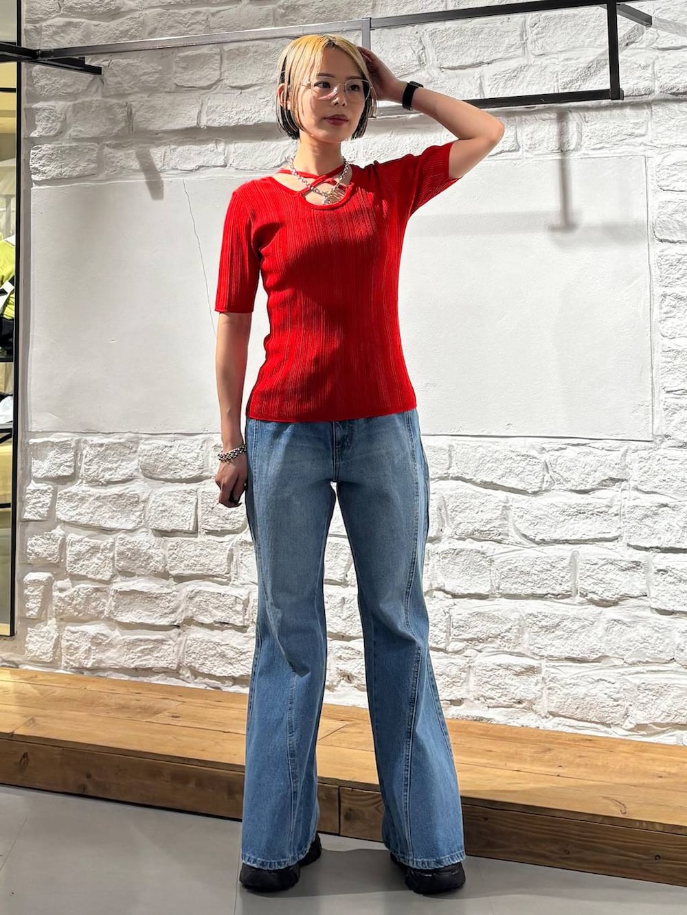 ブルー系のデニムパンツ、ブラック系のサンダル、レッド系のニット/セーターを着用したレディースの春コーディネートの6枚目の写真