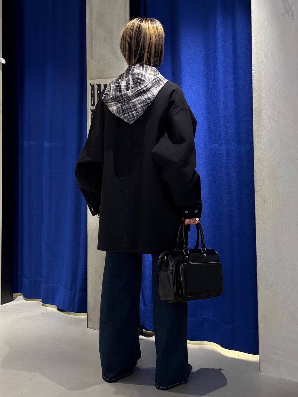 ブルー系のデニムパンツ、ブラック系のショルダーバッグ、ブラック系のサンダルを着用したレディースの春コーディネートの4枚目の写真
