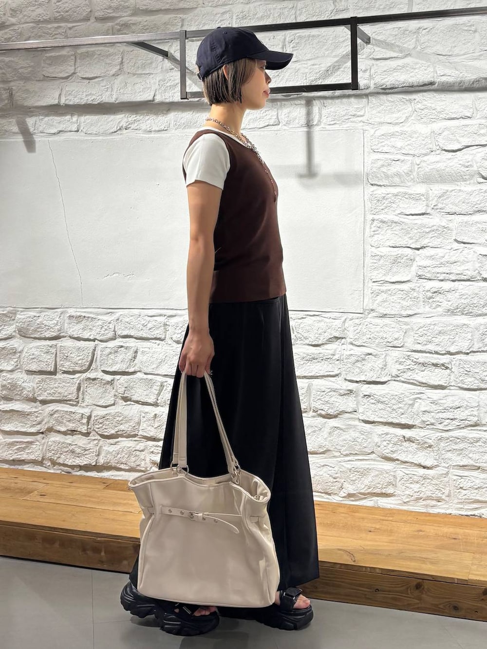 グレー系のサンダル、ブラウン系のタンクトップ、ホワイト系のTシャツ/カットソーを着用したレディースの夏コーディネートの4枚目の写真