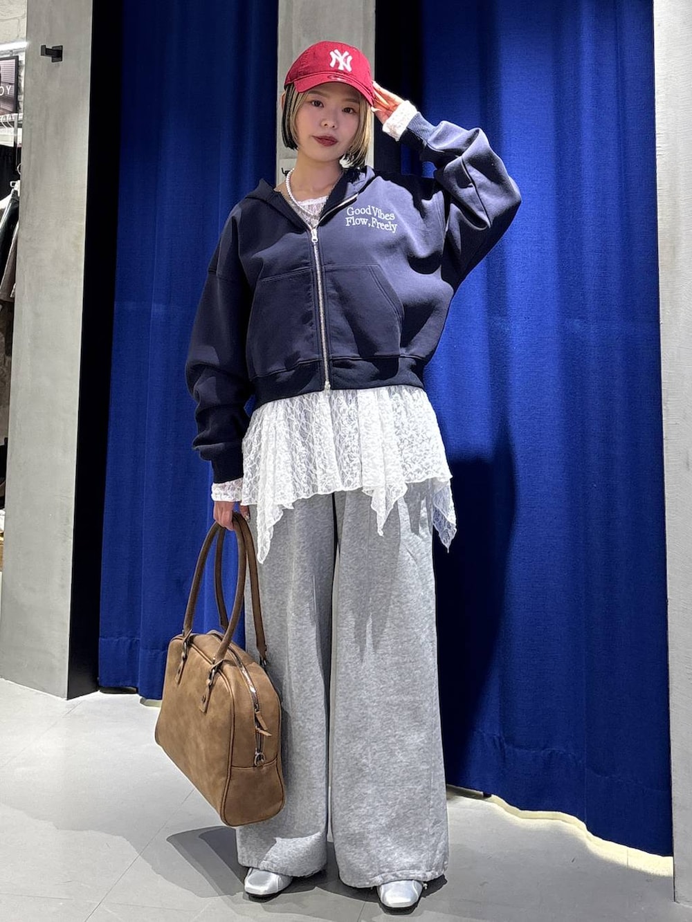 イエロー系のボストンバッグ、ブルー系のパーカー、グレー系のスウェットパンツを着用したレディースの冬コーディネートの4枚目の写真