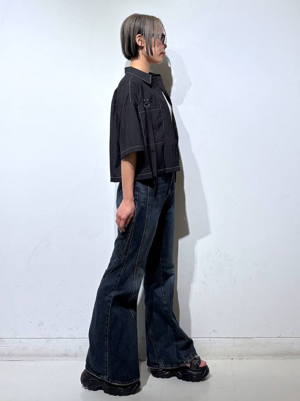 ブルー系のデニムパンツ、ホワイト系のタンクトップ、グレー系のサンダルを着用したレディースの春コーディネートの4枚目の写真