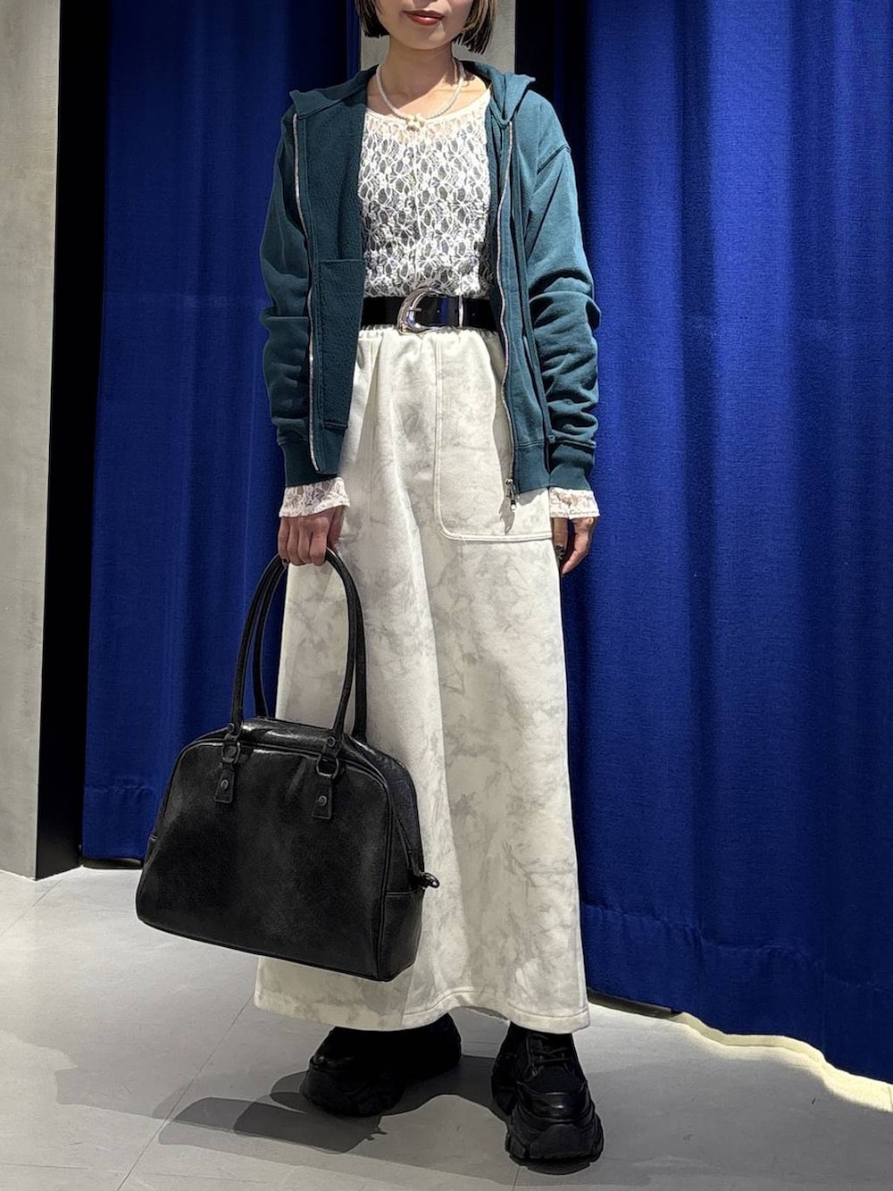 ブラック系のブーツ、ブラック系のボストンバッグ、ホワイト系のTシャツ/カットソーを着用したレディースの冬コーディネートの2枚目の写真