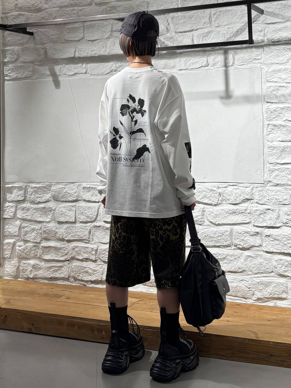ブラック系のブーツ、その他のデニムパンツ、ブラック系のショルダーバッグを着用したレディースの春コーディネートの5枚目の写真