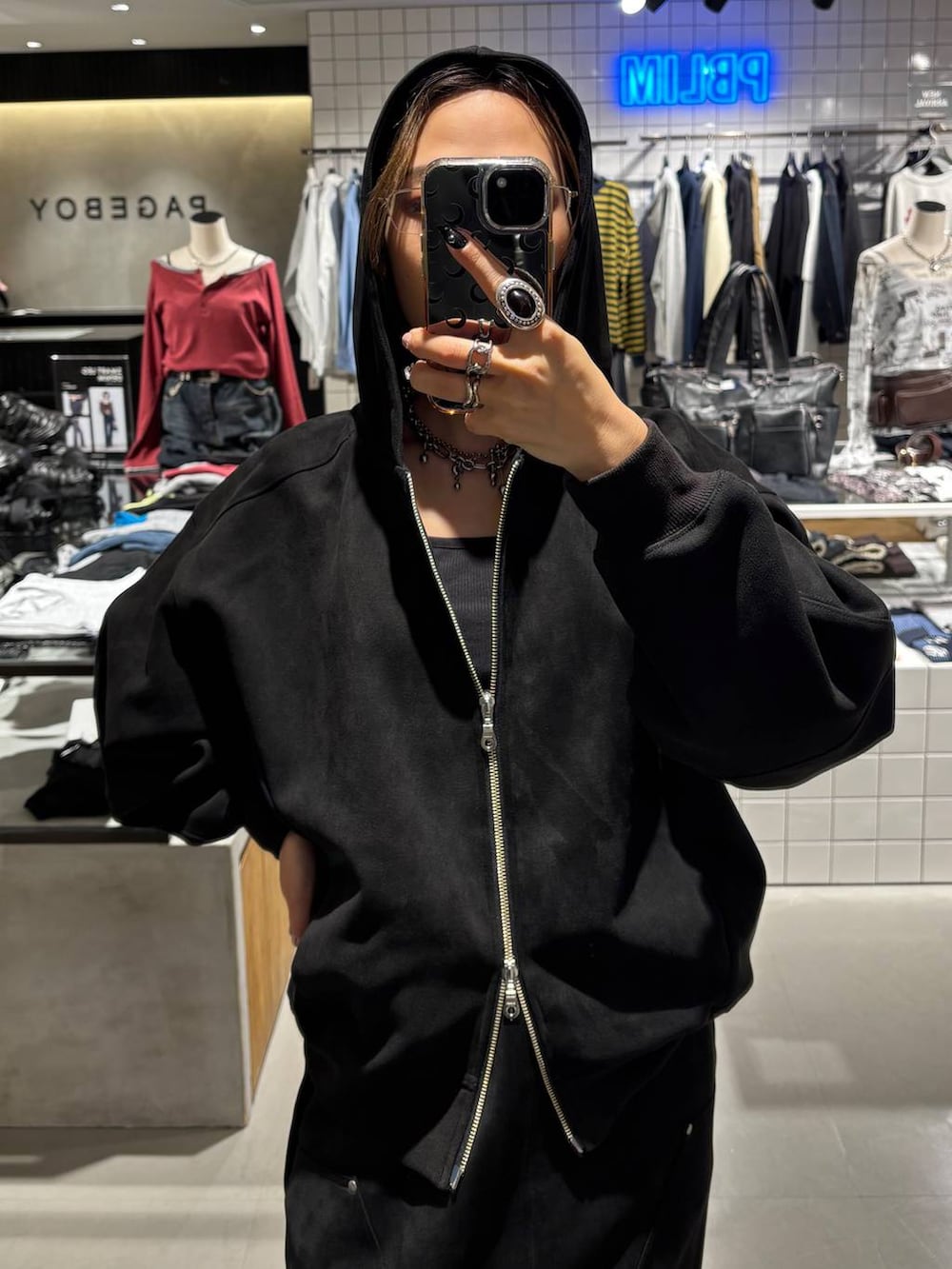 ブラック系のスカート、ブラック系のパーカー、ブラック系のスニーカーを着用したレディースの秋コーディネートの5枚目の写真