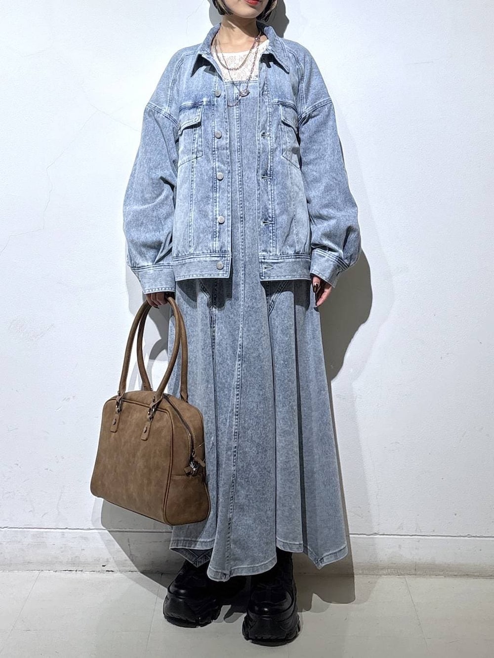 ブラック系のブーツ、ベージュ系のボストンバッグ、ホワイト系のTシャツ/カットソーを着用したレディースの春コーディネートの2枚目の写真