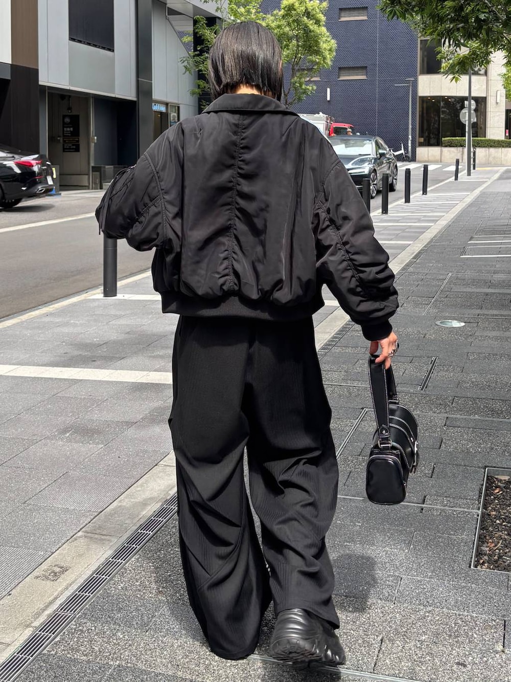 ブラック系のスニーカー、ブラック系のショルダーバッグ、ブラック系のキャミソールを着用したレディースの秋コーディネートの7枚目の写真