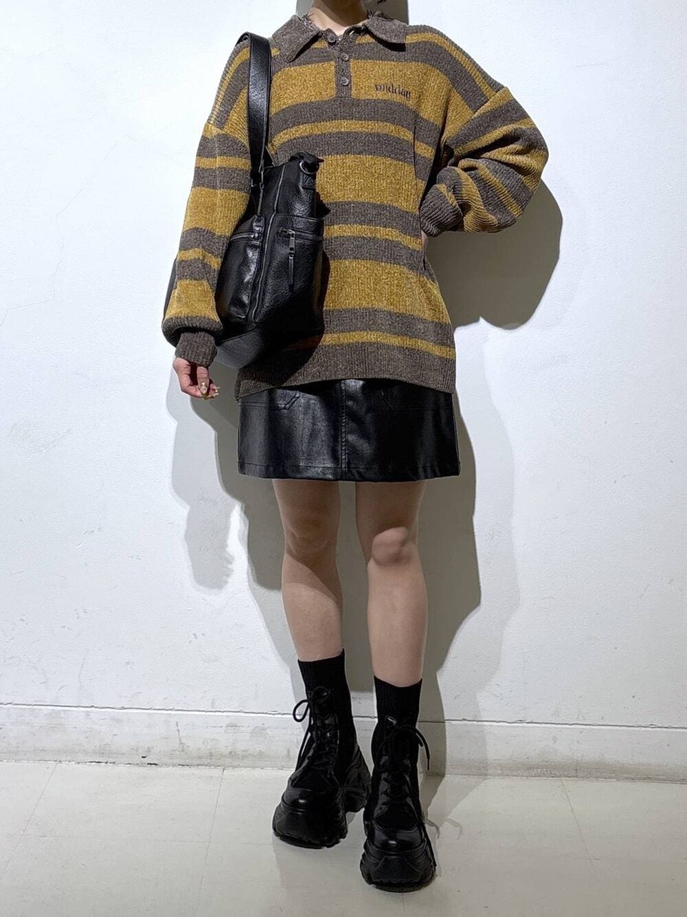 ブラック系のブーツ、ブラック系のボストンバッグ、ブラック系のスカートを着用したレディースの冬コーディネートの2枚目の写真