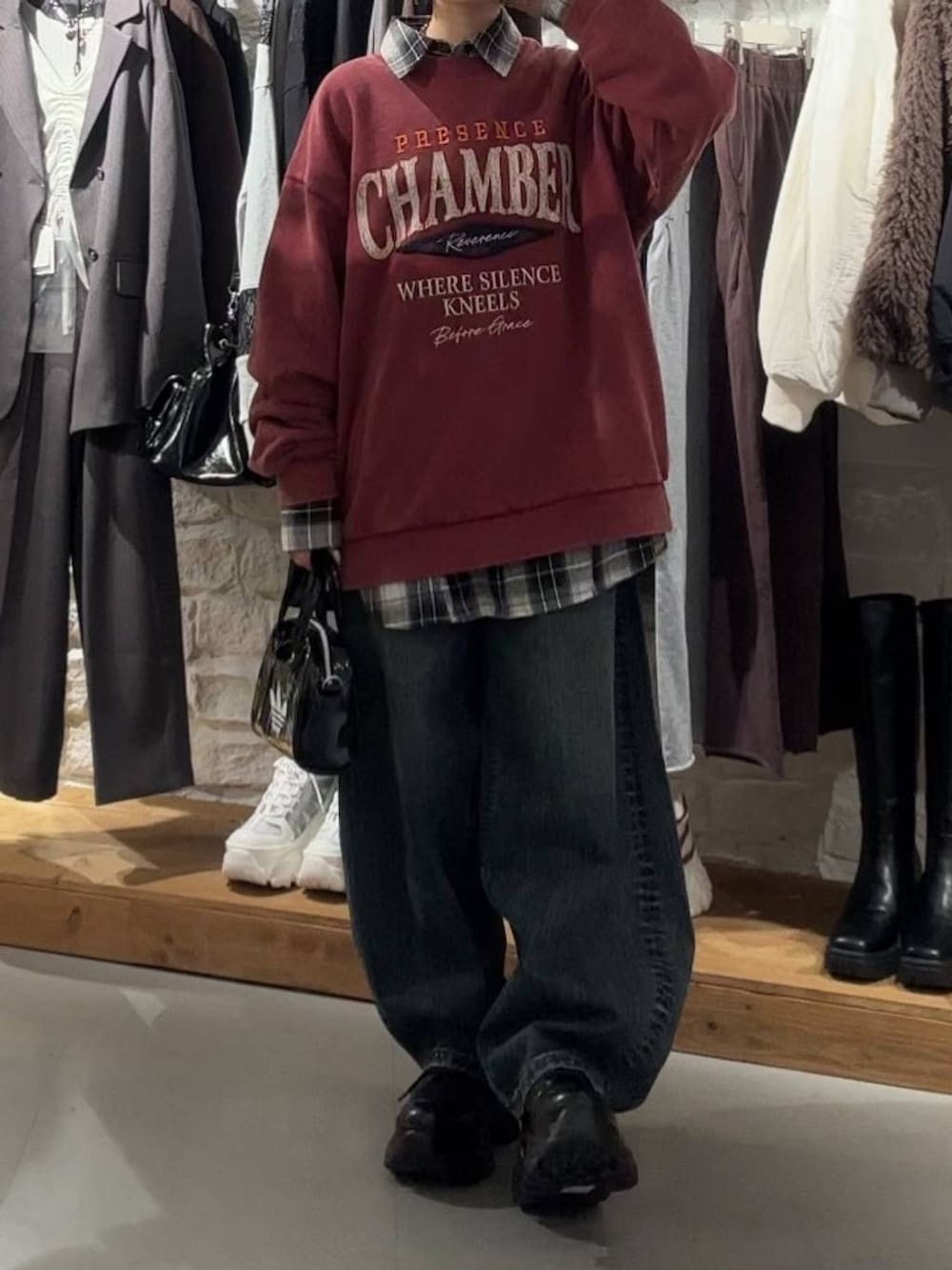 ブラック系のブーツ、レッド系のスウェット、ブラック系のTシャツ/カットソーを着用したレディースの秋コーディネートの2枚目の写真